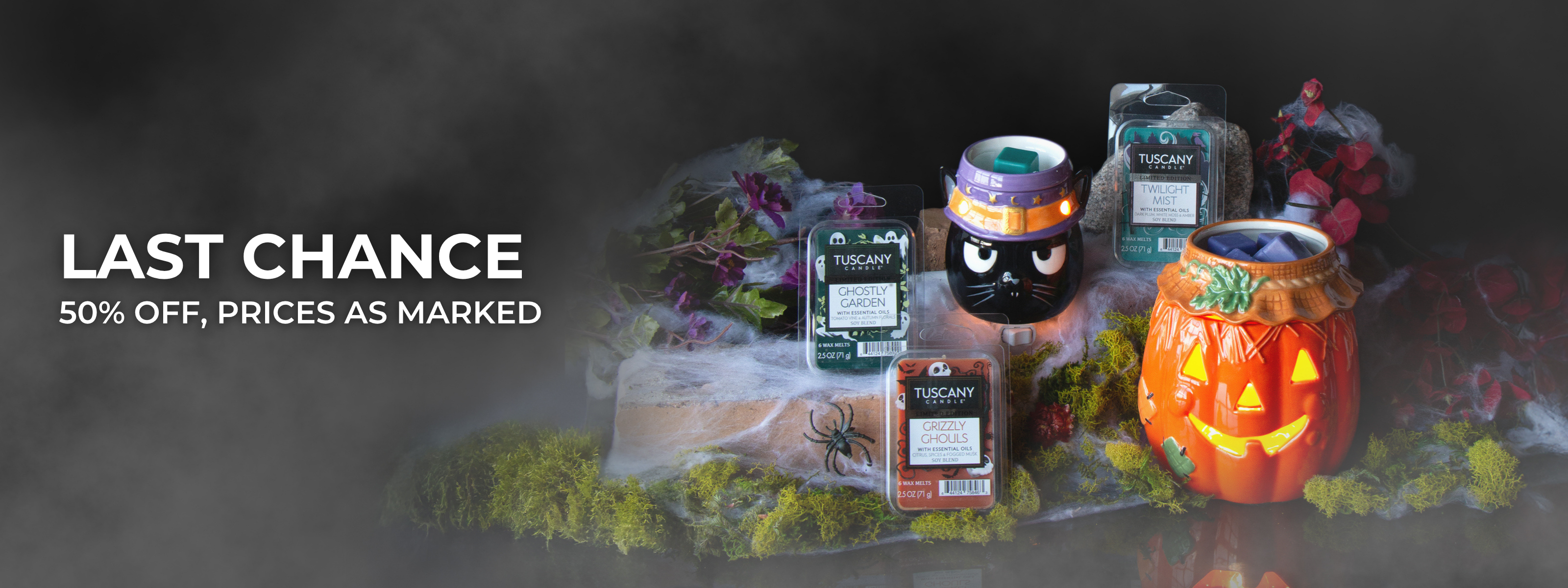 A cozy scene with a chair, a yellow pillow, a round table holding a lit candle, a pumpkin mug, two orange candles, and decorative pumpkins.