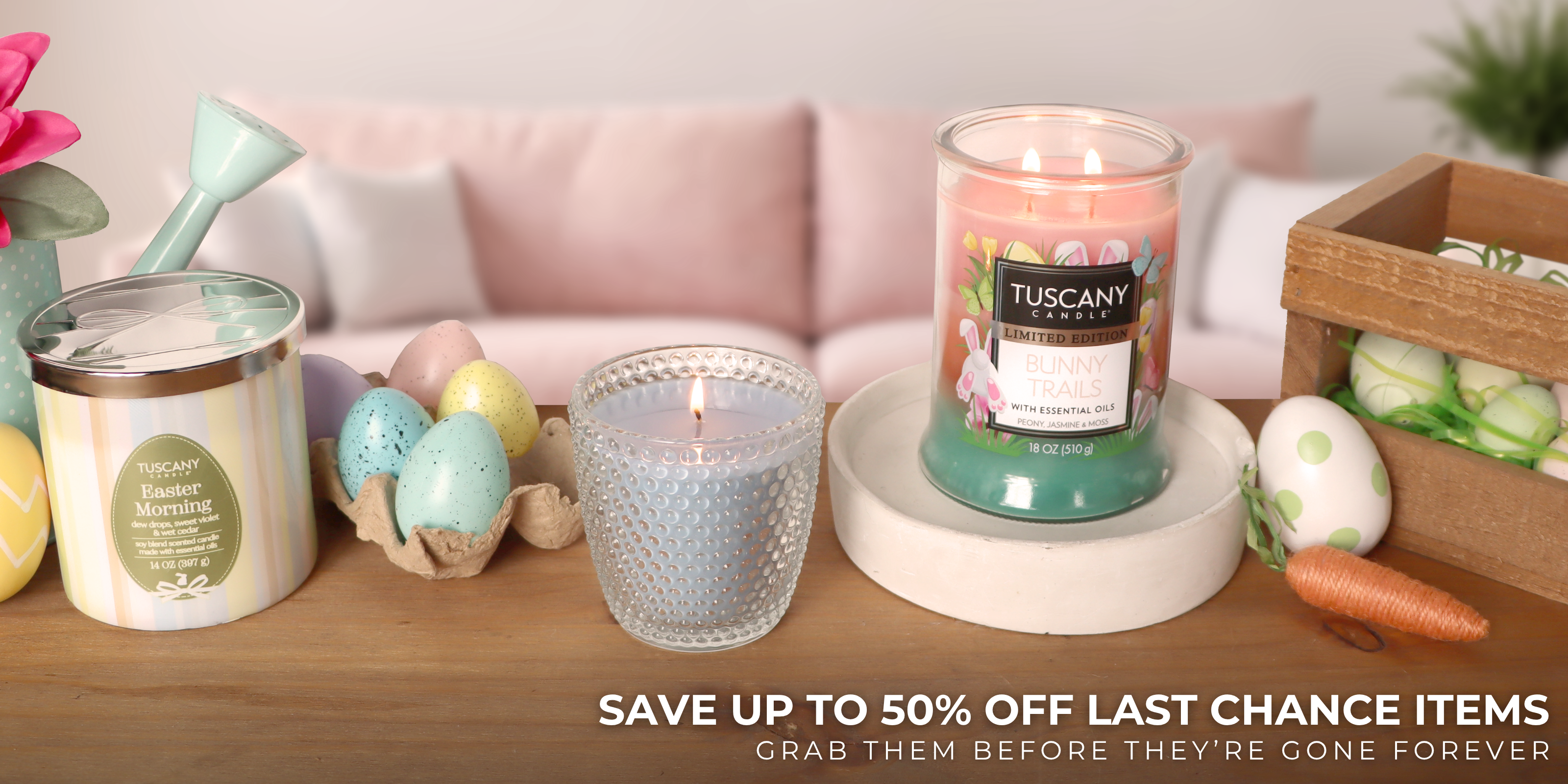 A cozy scene with a chair, a yellow pillow, a round table holding a lit candle, a pumpkin mug, two orange candles, and decorative pumpkins.