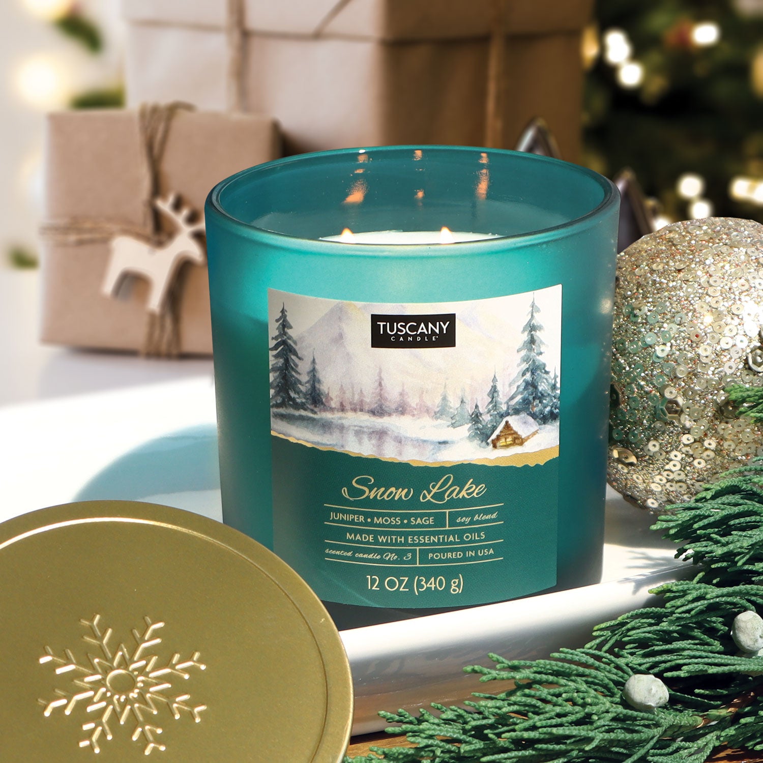 12oz Snow Lake scented candle in a painted glass jar with a golden lid, filled with white wax, emitting fragrances of juniper berries, crushed moss, and frosted sage from the Winter candle collection.