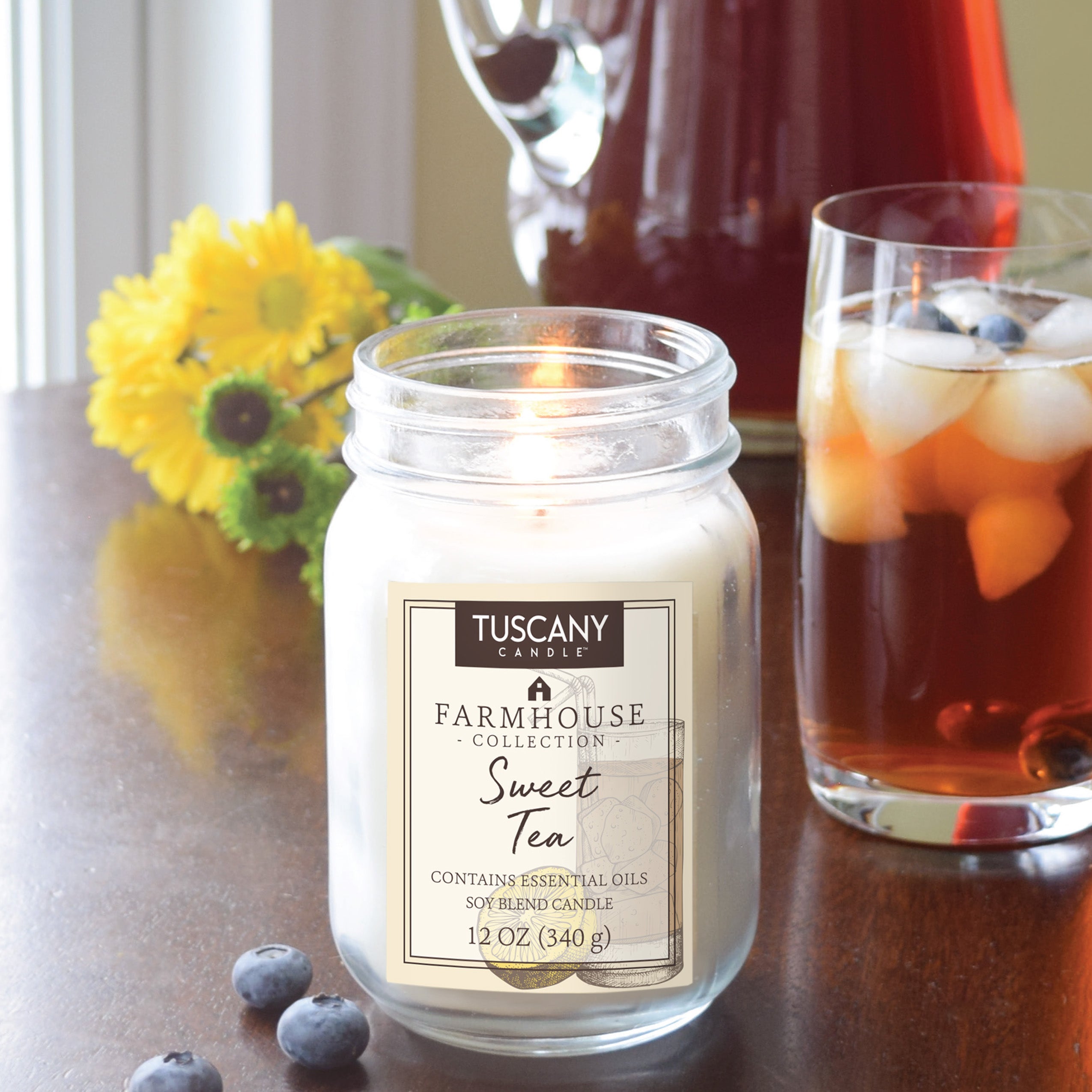 A Sweet Tea Scented Jar Candle (12 oz) from the Farmhouse Collection by Tuscany Candle on a table, exuding southern charm and nostalgic vibes.