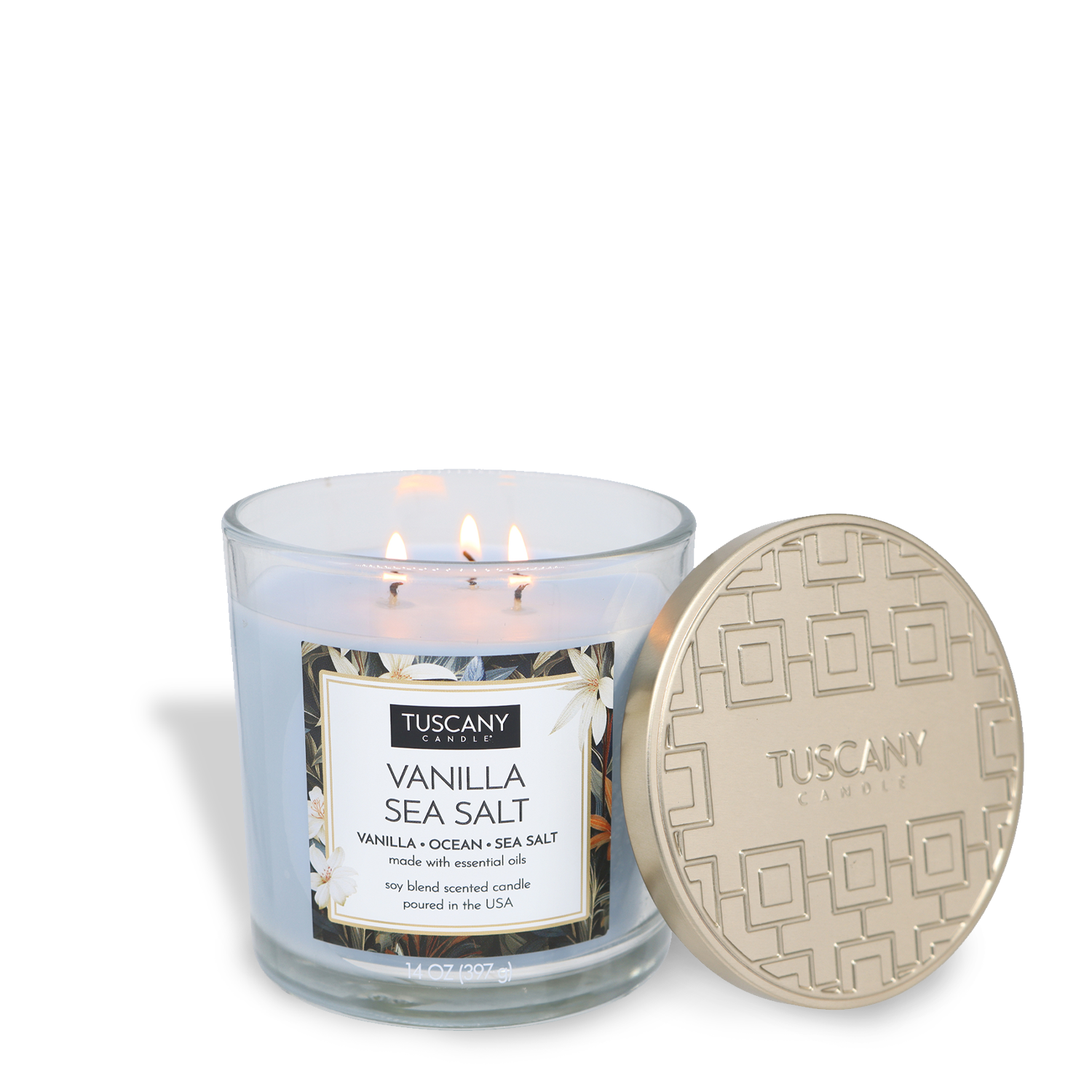 The Tuscany Candle® EVD Vanilla Sea Salt Long-Lasting Scented Jar Candle (14 oz) features three lit wicks in a glass jar, filling your space with a soothing aroma while its gold lid rests beside it.