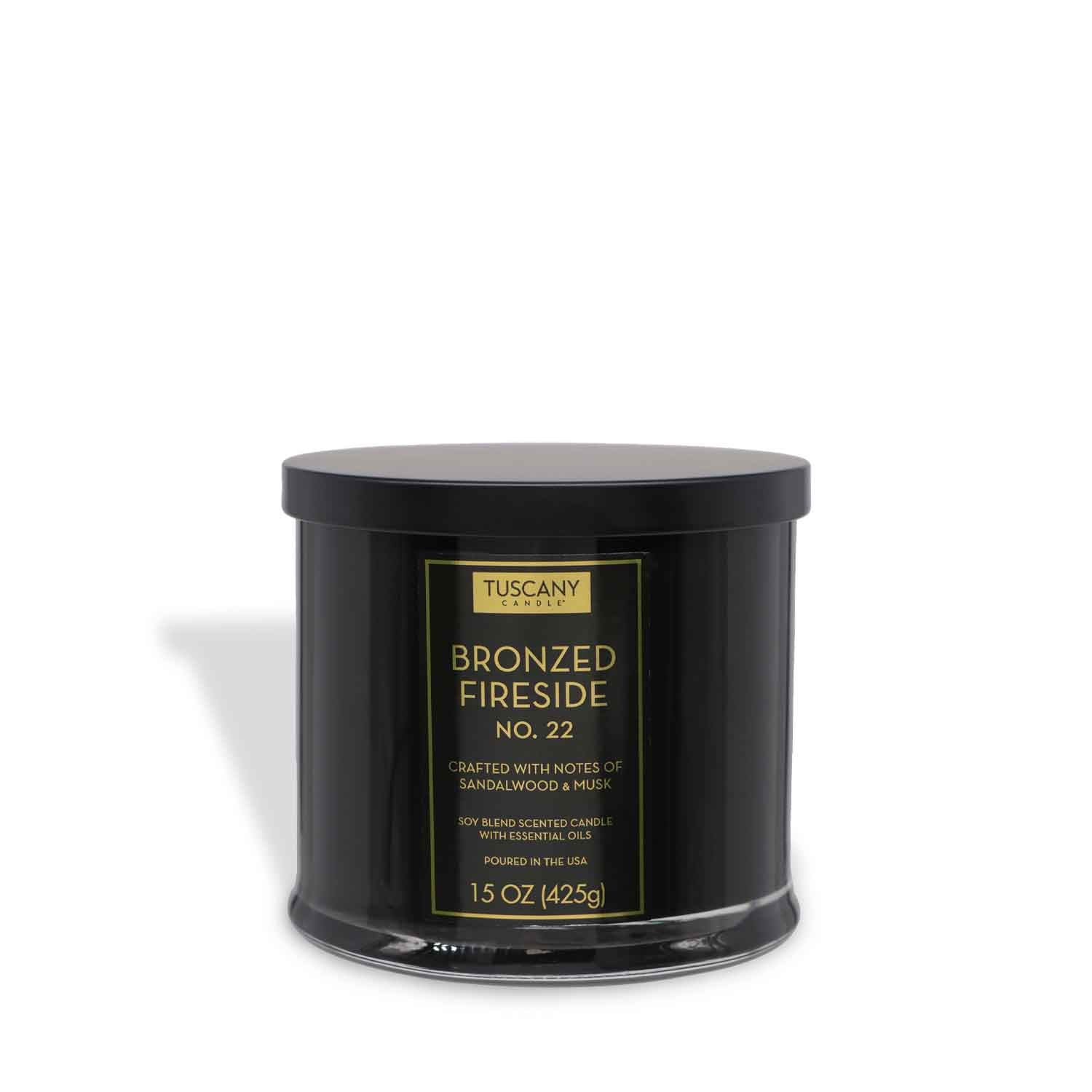 The Tuscany Candle® EVD Bronzed Fireside Scented Jar Candle (15 oz) from the Homme + Heritage Collection features warm sandalwood and musk notes, a sleek black jar with matching lid, and offers long-lasting fragrance.