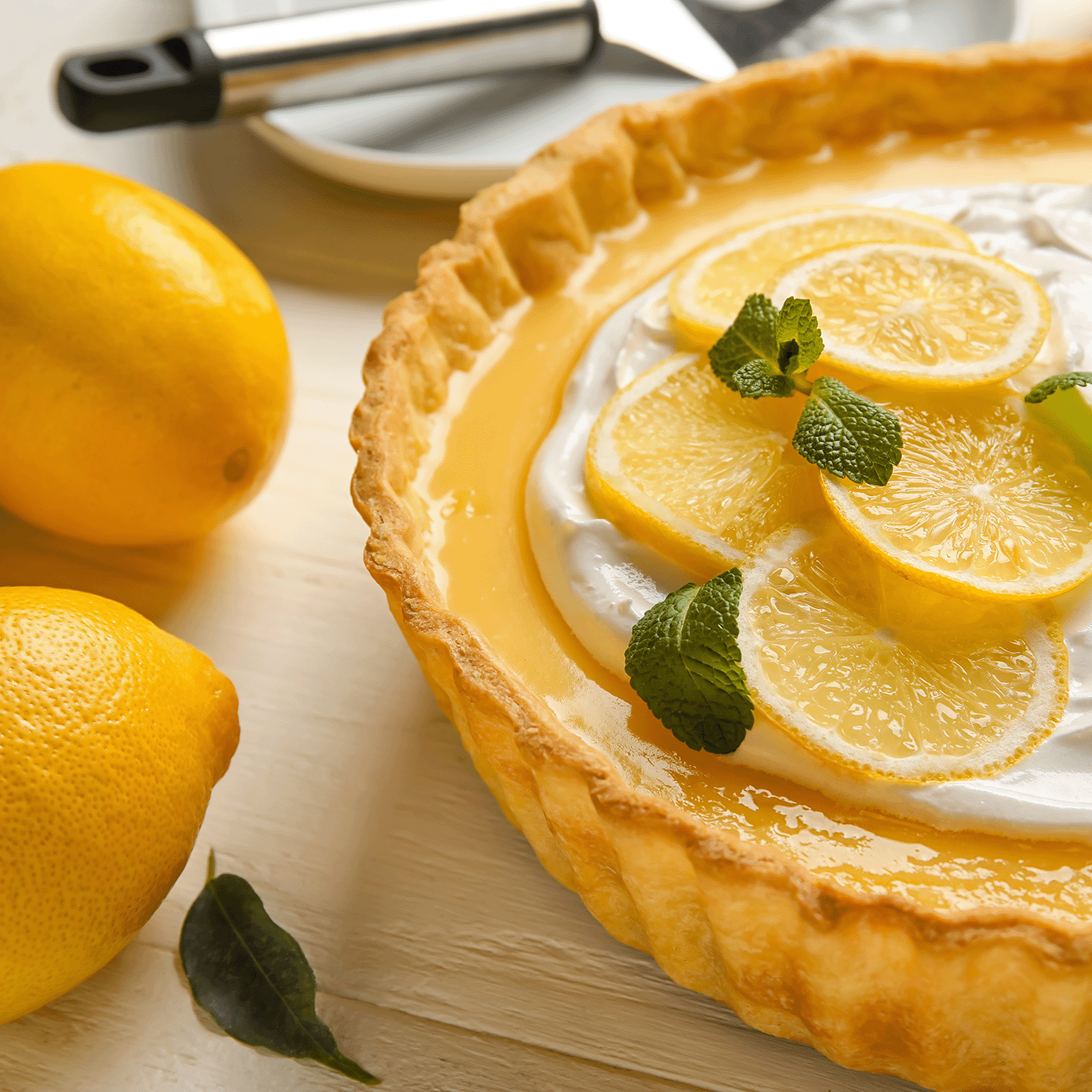 The Frosé Lemonade: Tart Citrus Scented Candle (12 oz) from Tuscany Candle® SEASONAL, part of the Gourmet Sorbet Collection, rests on a light wooden surface beside two whole lemons.