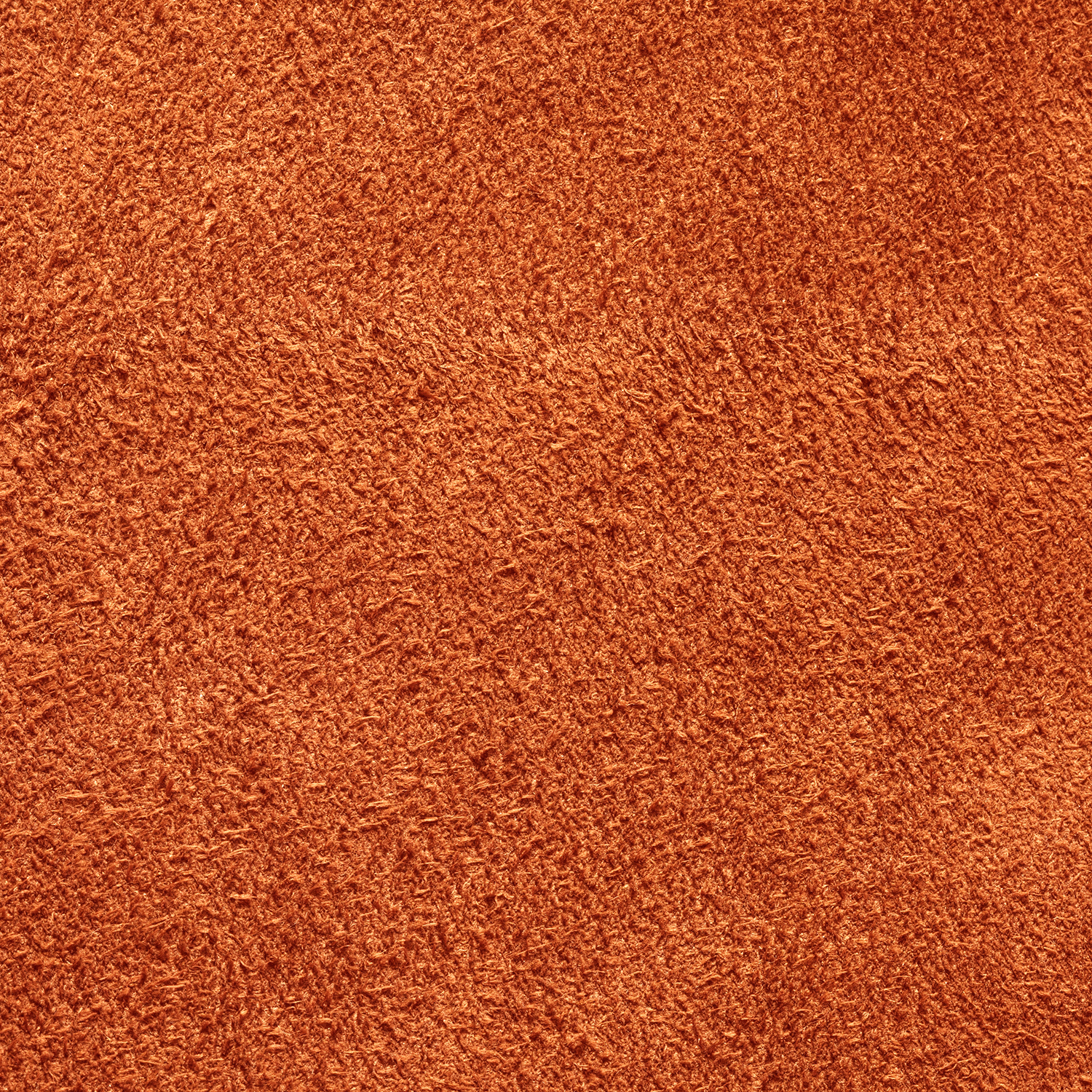Close-up of an orange textured plush carpet, perfect for cozy evenings when paired with Tuscany Candle® SEASONAL Vanilla Suede: Sandalwood & Mandarin Scented Fall Candle (12 oz).