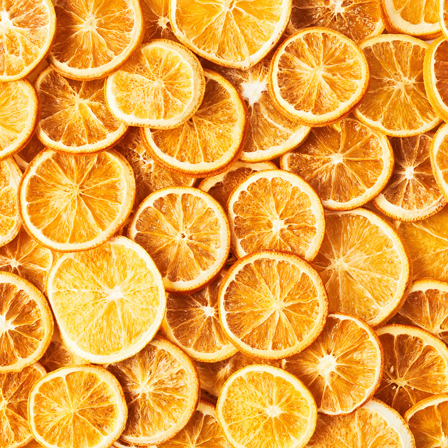 A pile of evenly sliced, dried orange rounds with vibrant hues—perfect for pairing with Tuscany Candle® SEASONAL Fall Festival: Cinnamon & Clove Scented Fall Candle (18 oz) for a cozy autumn atmosphere.
