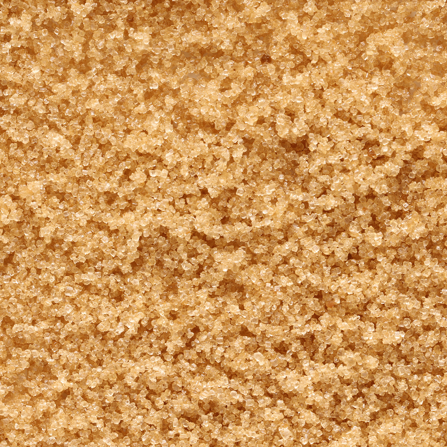 Close-up of raw brown sugar crystals highlighting their golden, coarse texture—ideal for evoking the essence of Tuscany Candle® SEASONAL Ginger Spice Cake: Carrot & Vanilla Scented Fall Candle (18 oz).