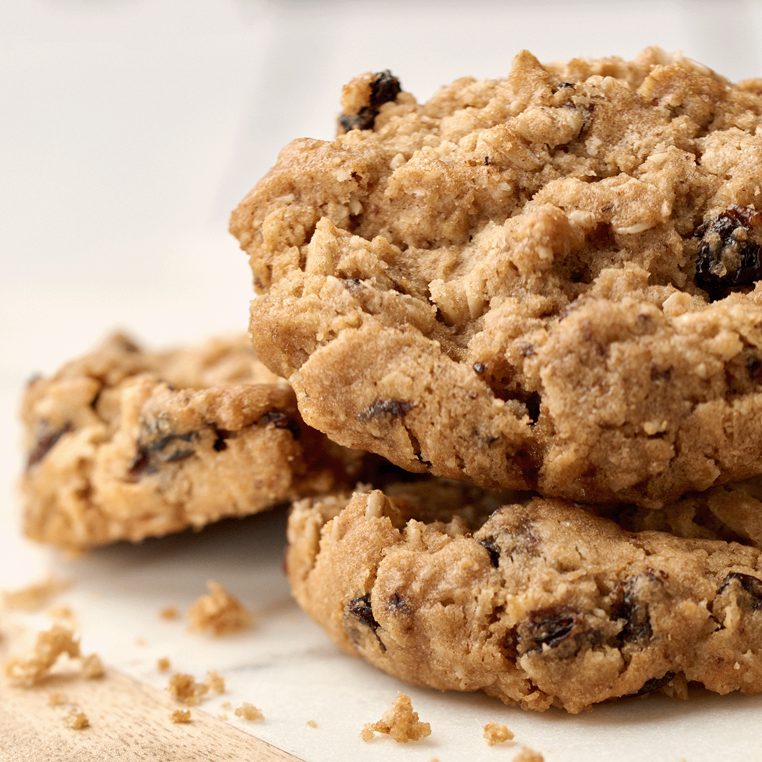Close-up of two oatmeal raisin cookies on parchment evokes the cozy scent of Tuscany Candle® SEASONAL Harvest Cookies: Brown Sugar & Vanilla Scented Fall Wax Melt (2.5 oz)—a soy wax tart bar with warm fall baking fragrance.