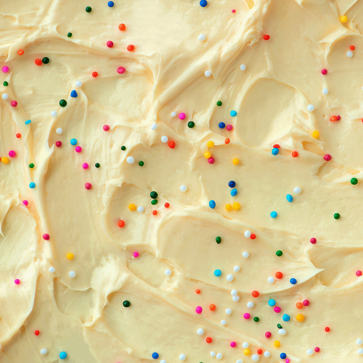 Experience the tempting scent of buttercream icing and vanilla with Tuscany Candle® SEASONAL Charmed Sweets: Vanilla Cupcake & Buttercream Icing Scented Halloween Candle (14 oz), featuring creamy yellow frosting and colorful sprinkles.