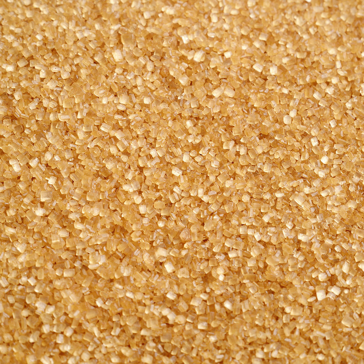 A close-up of coarse brown sugar crystals, evoking the sweet aroma of Tuscany Candle® SEASONAL’s Gingerbread Village: Classic Gingerbread & Sugar Scented Holiday Candle (14 oz) from the Traditions Collection.