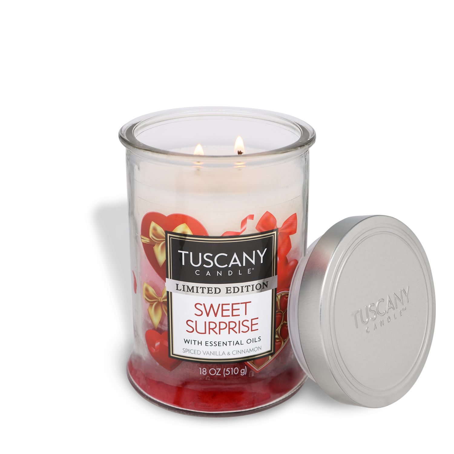 A Tuscany Candle® SEASONAL "Sweet Surprise: Vanilla & Cinnamon Scented Valentine's Candle" (18 oz) features essential oils, a heart-decorated glass jar, and a lid placed beside it.