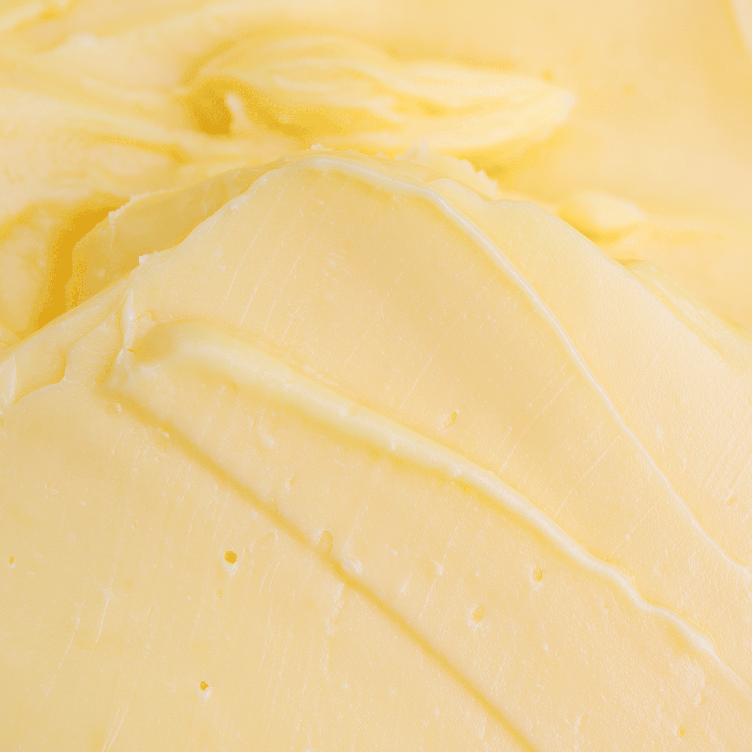 Close-up of smooth, creamy pale yellow wax—Sunday Morning: Maple Butter Pancakes Scented Spring Wax Melt (2.5 oz) by Tuscany Candle® SEASONAL evokes the rich aroma of maple butter pancakes.