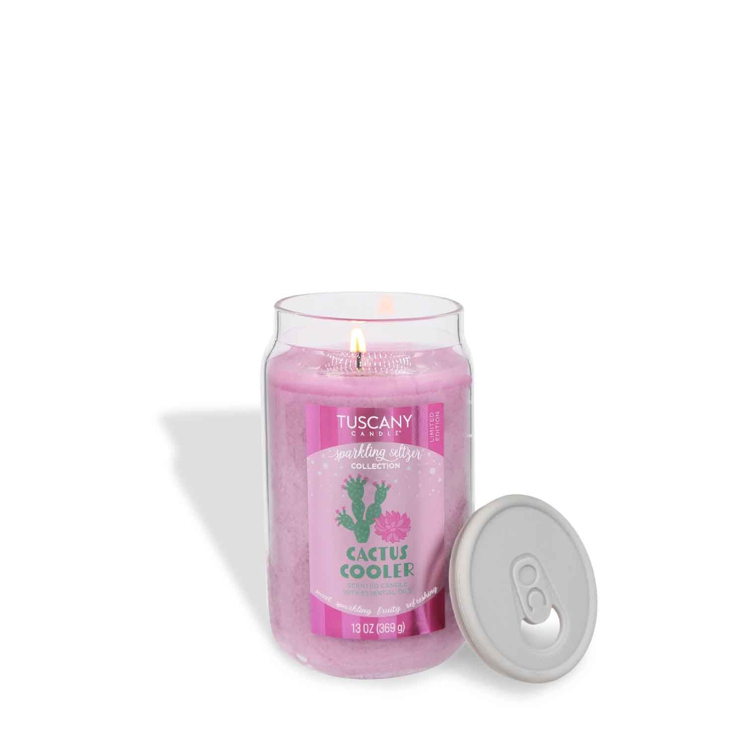 A 13 oz Tuscany Candle® SEASONAL "Cactus Cooler: Sparkling Seltzer Scented Summer Candle" burns in a pink glass jar with a gray lid beside it, set against a white background.
