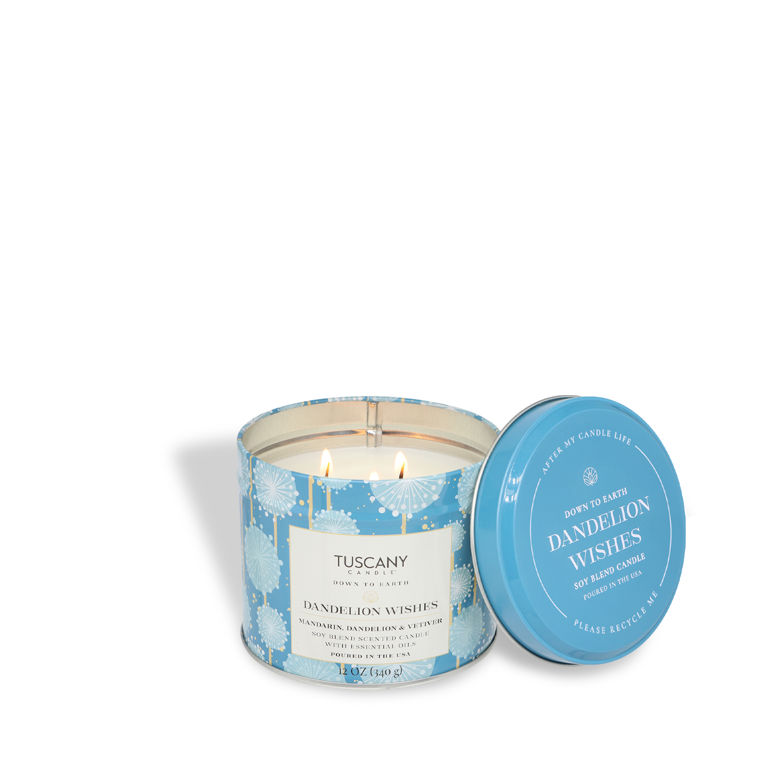 A 12oz white, double-wick soy blend candle from Tuscany Candle® SEASONAL’s Down to Earth Collection sits in a blue tin labeled “Dandelion Wishes: Mandarin & Vetiver,” featuring delicate white dandelion designs. Lid rests beside the citrus-scented candle.