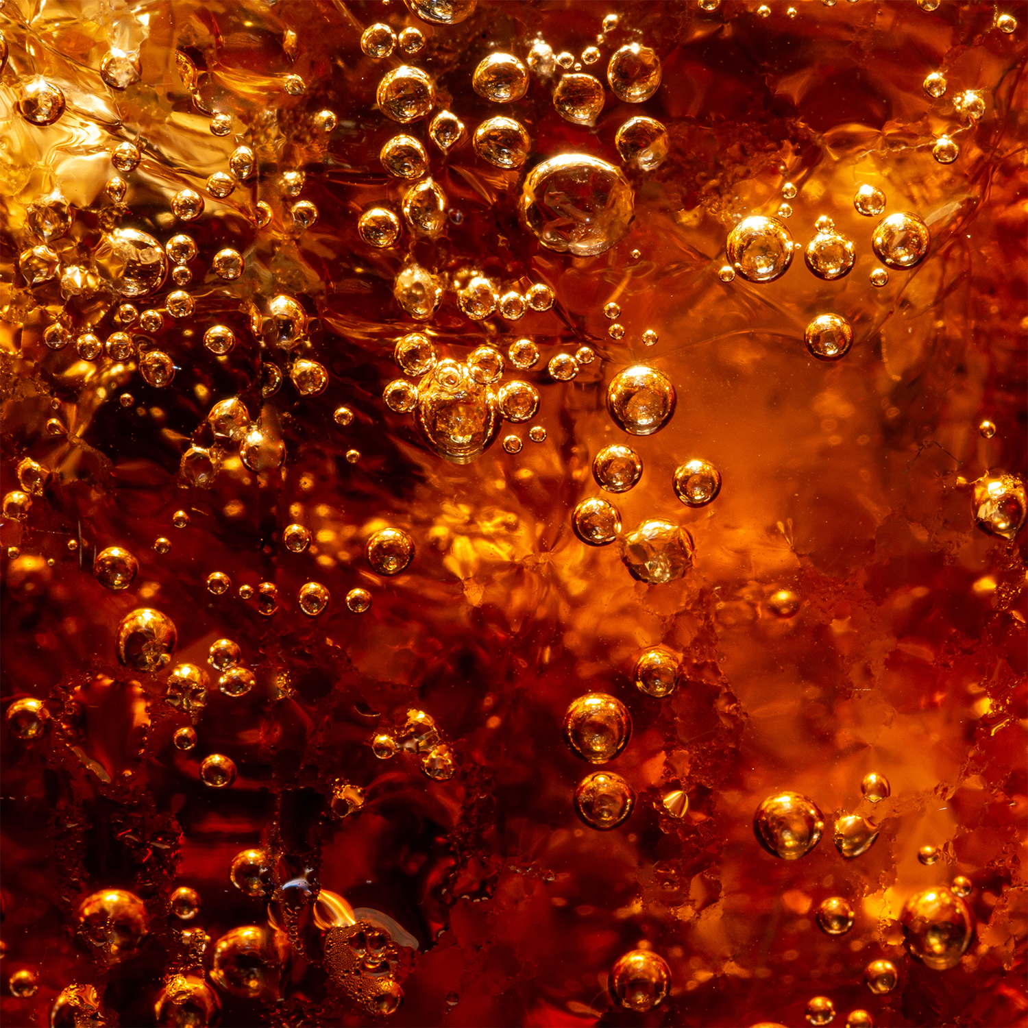 Close-up of Tuscany Candle® SEASONAL Spooky Soda: Pumpkin & Cream Soda Scented Halloween Wax Melt (2.5 oz) with visible bubbles and ice, creating a sparkling effect in a reddish-brown wax melt.