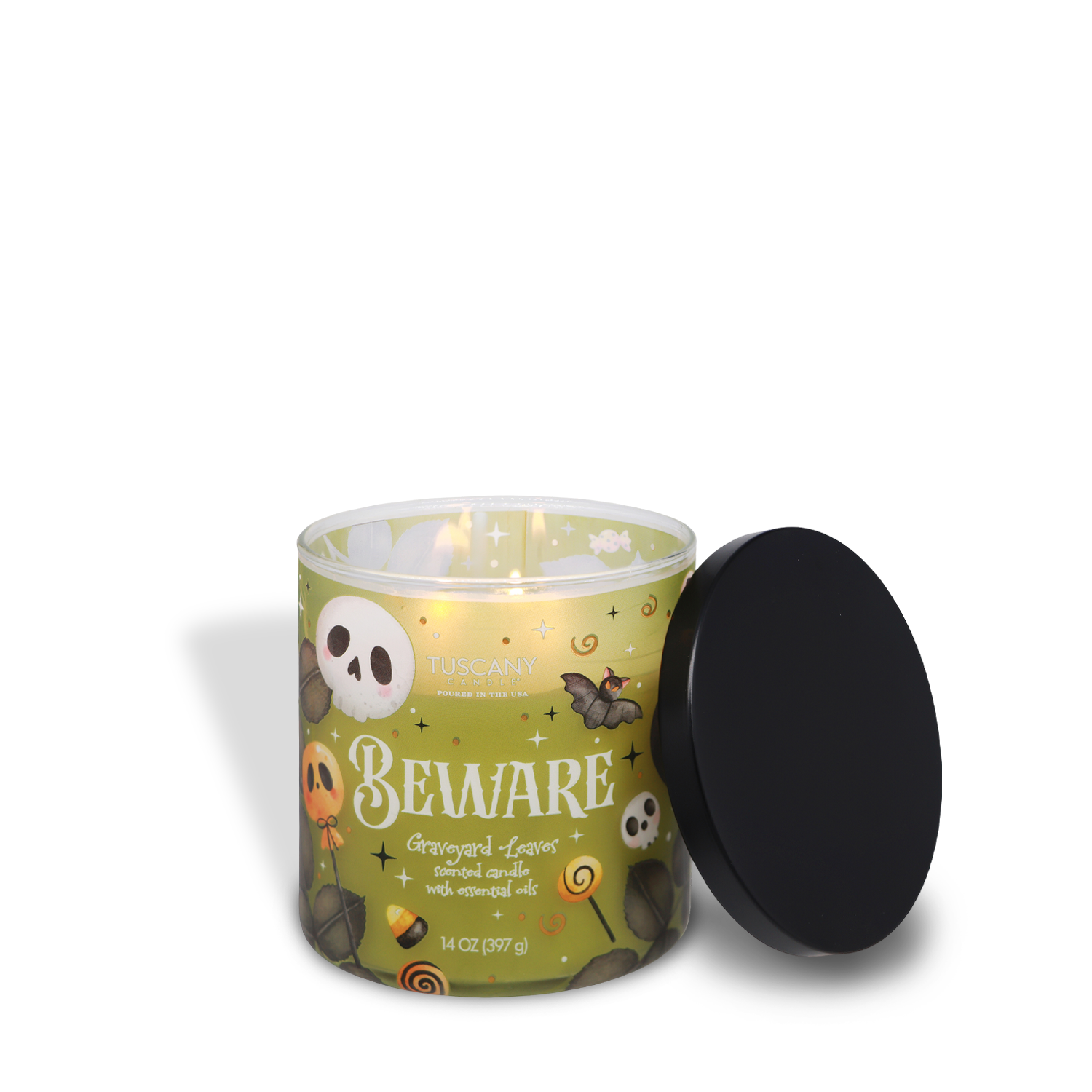 A lit Tuscany Candle® SEASONAL “Beware: Graveyard Leaves” Scented Halloween Candle (14 oz) sits in a jar decorated with Halloween-themed designs, with the black lid placed beside it.