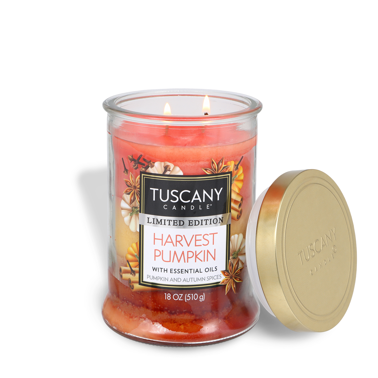 An 18 oz Tuscany Candle® SEASONAL Harvest Pumpkin: Pumpkin & Autumn Spices Scented Fall Candle in a glass jar with a gold lid, lit and decorated with autumn designs.