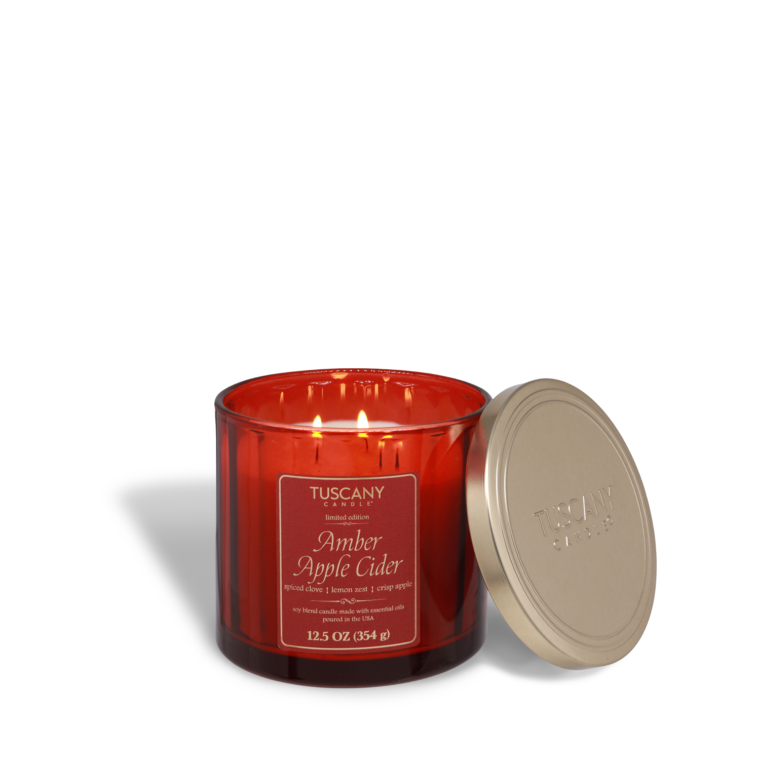A lit Tuscany Candle® SEASONAL Amber Apple Cider: Clove & Lemon Zest Scented Fall Candle (12.5 oz) in a red glass jar, labeled "Amber Apple Cider," with the gold lid resting nearby—perfect for filling any space with a warm autumn home fragrance.