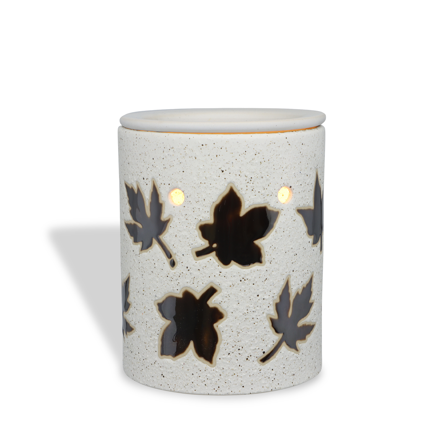 The Autumn Leaf Outlet Wax Melt Warmer by Tuscany Candle® SEASONAL is a white ceramic warmer with cut-out leaf patterns, casting a glowing shadow left. Enjoy flameless fragrance in any room, perfect for autumn décor.