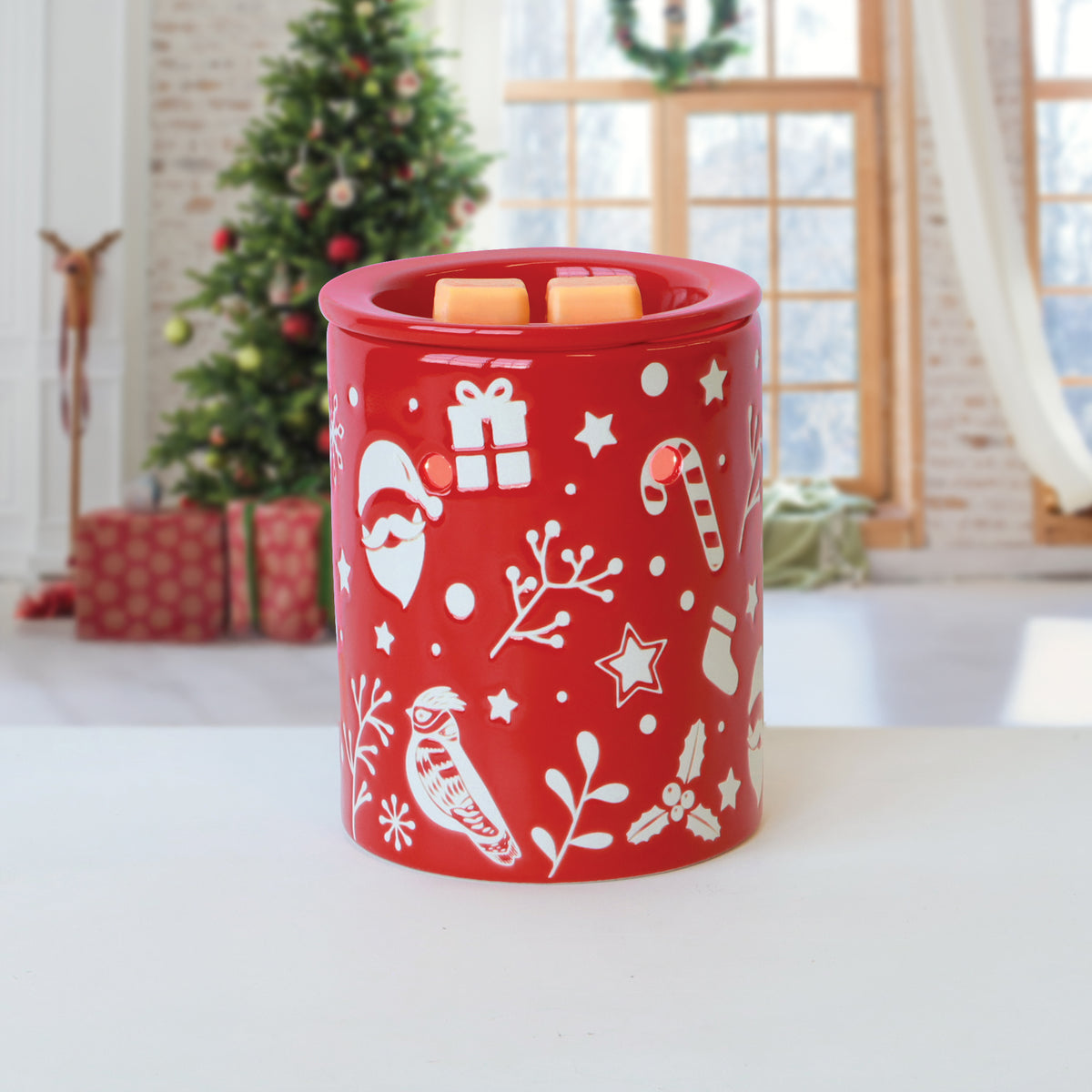 Red wax warmer decorated with white holiday icons and two cubes of Christmas Cookies: Cinnamon Spice & Vanilla Scented Holiday Wax Melt (2.5 oz) melting on top.