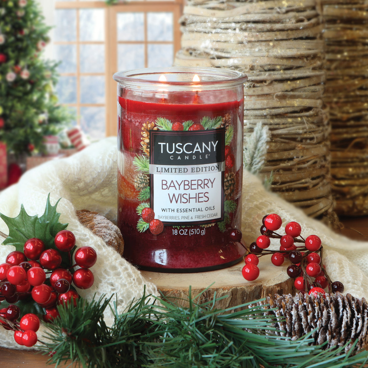 Bayberry Wishes: Bayberries & Pine Scented Holiday Candle (18 oz) in a two-wick red wax jar, surrounded by holly berries, pine branches, and a white knit throw.