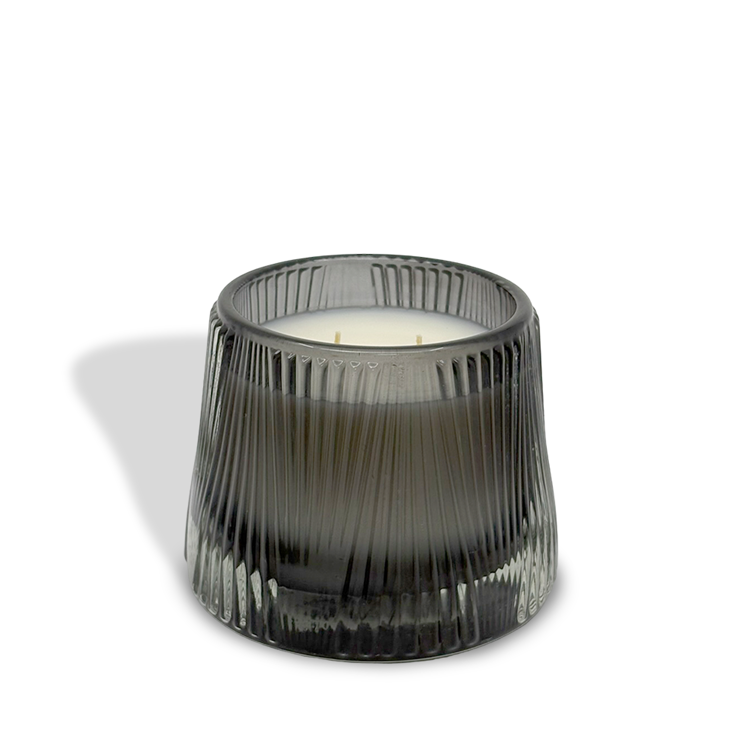 The est.1951 Bergamot & Musk (9oz) candle features a black ribbed glass holder and white vegan wax with three wicks, casting a shadow on a white background.