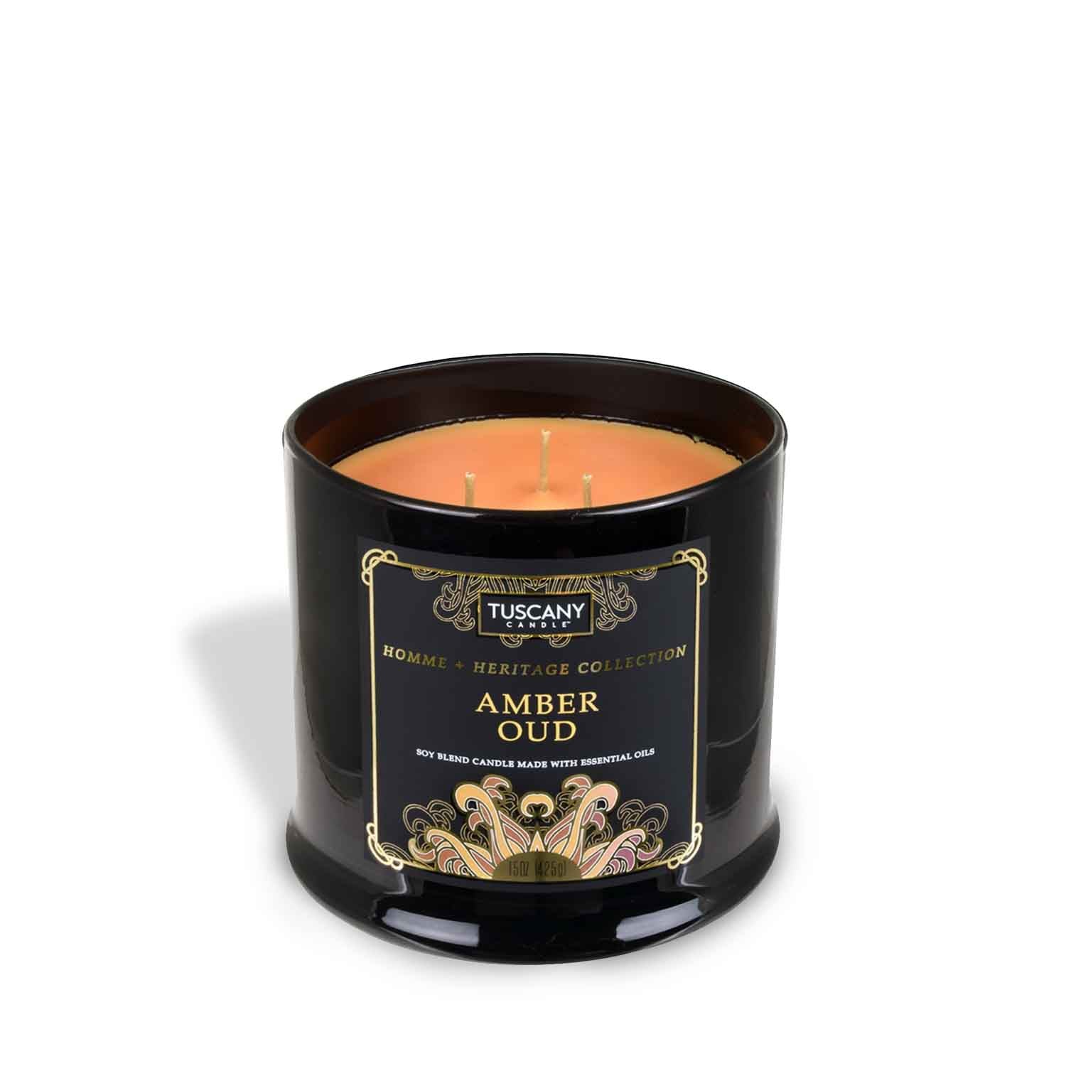 An Amber Oud scented candle in a black tin with a gold lid from the Tuscany Candle brand.