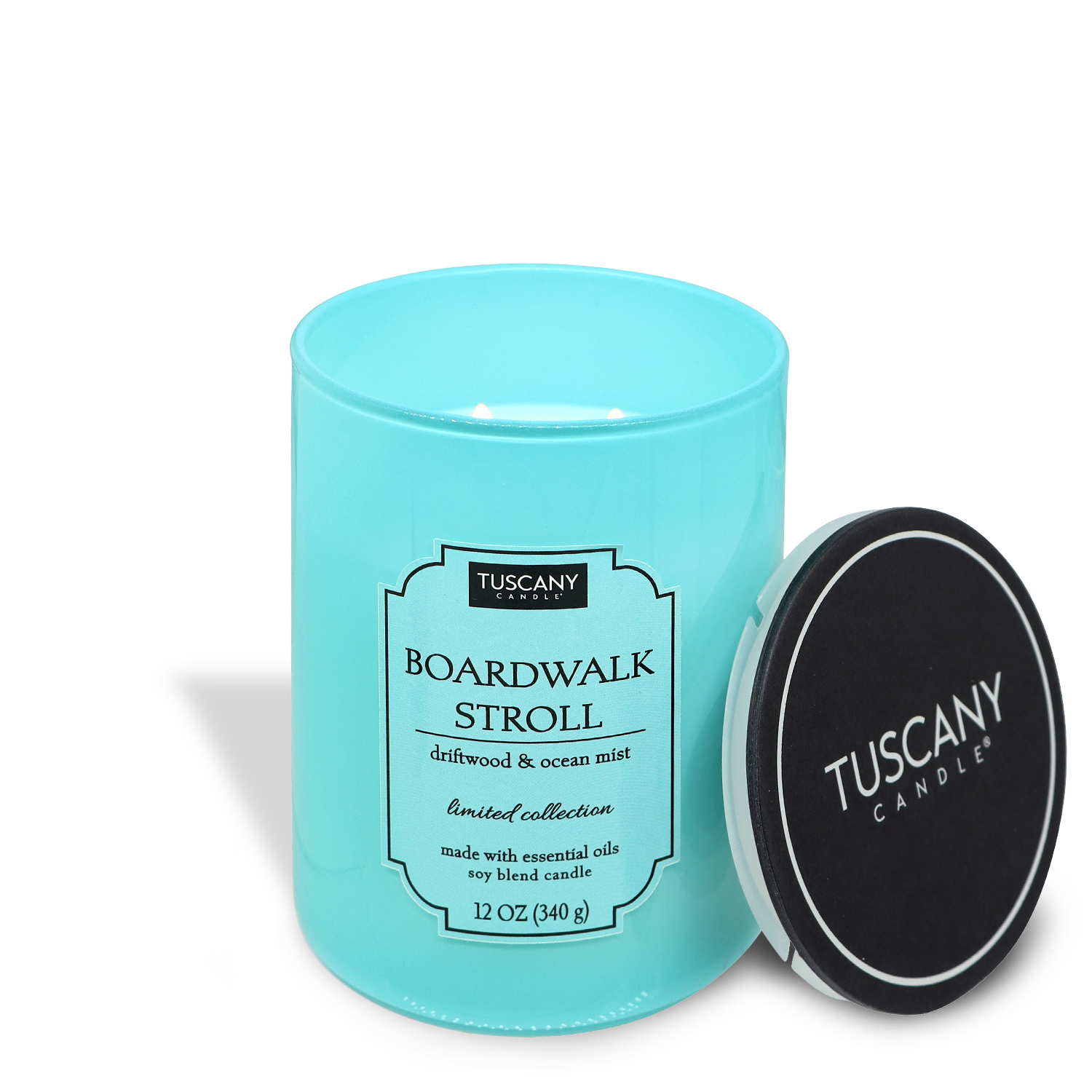Turquoise "Boardwalk Stroll (12 oz) – Colorsplash Collection" scented candle by Tuscany Candle®, featuring driftwood and ocean mist fragrance, displayed with its black lid to the side.