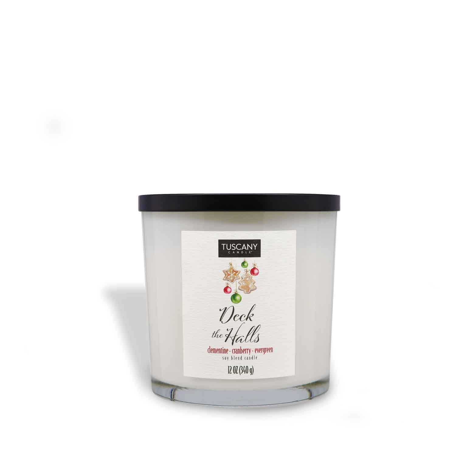 2oz Deck The Halls scented candle in a glossy white glass jar with a gold lid, emanating the festive blend of clementine, cranberry, and evergreen from the Winter candle collection.