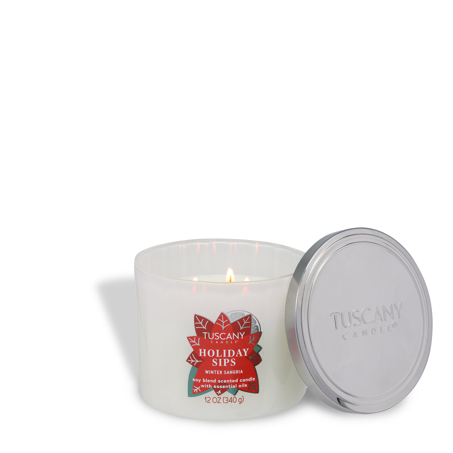 A lit Tuscany Candle® SEASONAL "Holiday Sips: Winter Sangria Scented Holiday Candle" (12 oz) from the Winter Icons Collection sits beside its silver lid on a white background.
