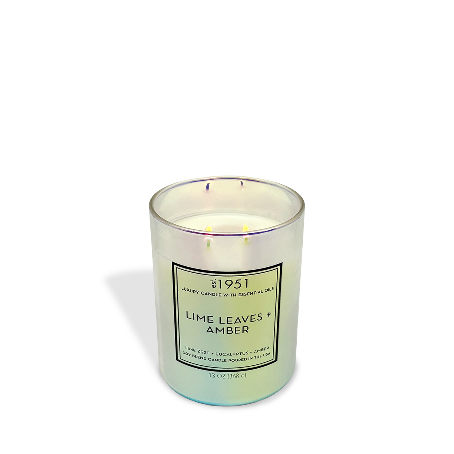 An est.1951 Lime Leaves + Amber (13oz) candle with three wicks glows on a white background, releasing a fresh citrus scent.