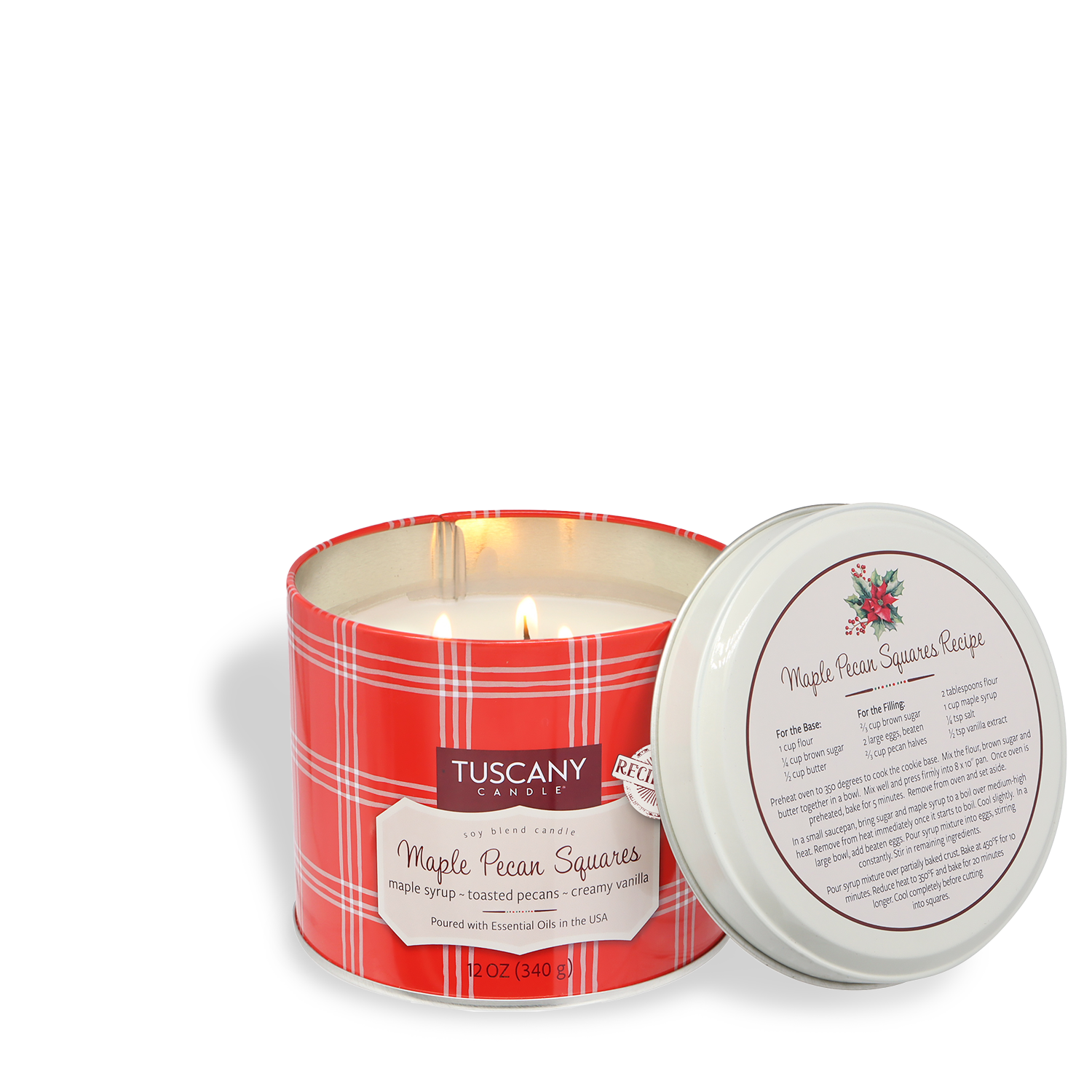A Tuscany Candle® SEASONAL "Maple Pecan Squares: Maple & Cinnamon Pancake Scented Holiday Candle" (12 oz) from the Bakery Tins Collection is lit, with its lid off, revealing a printed recipe inside.