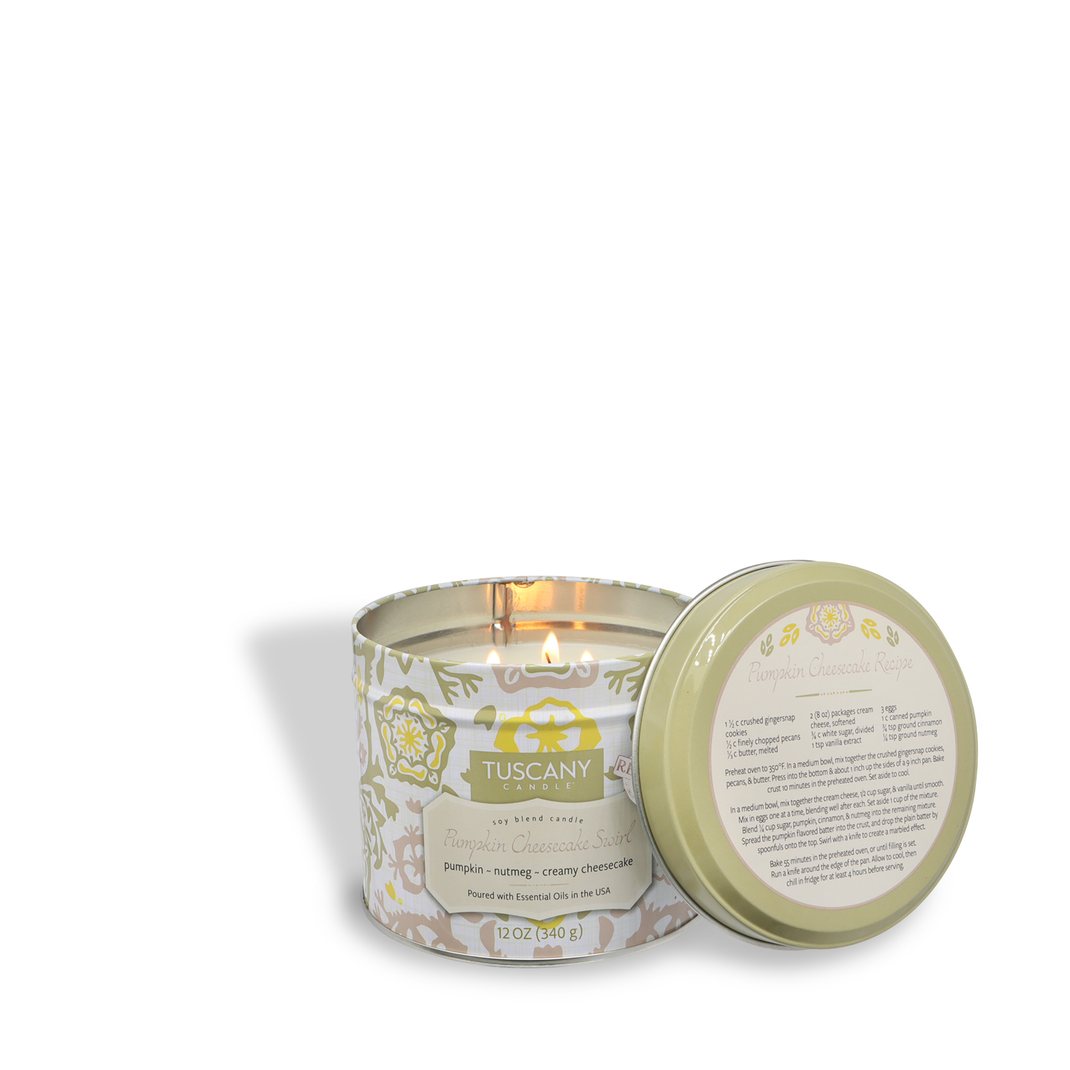 A lit Tuscany Candle® SEASONAL Pumpkin Cheesecake Swirl: Cinnamon & Vanilla Scented Fall Candle (12 oz) from the Bakery Tins Collection sits in a round tin with its lid beside it, displayed on a white background.