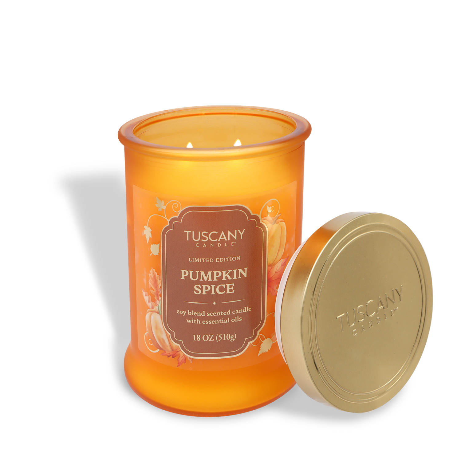 An 18 oz Tuscany Candle® SEASONAL jar, labeled "Pumpkin Spice: Nutmeg & Clove Scented Fall Candle," sits open with the lid beside it. The candle is lit, featuring a fall-themed design.