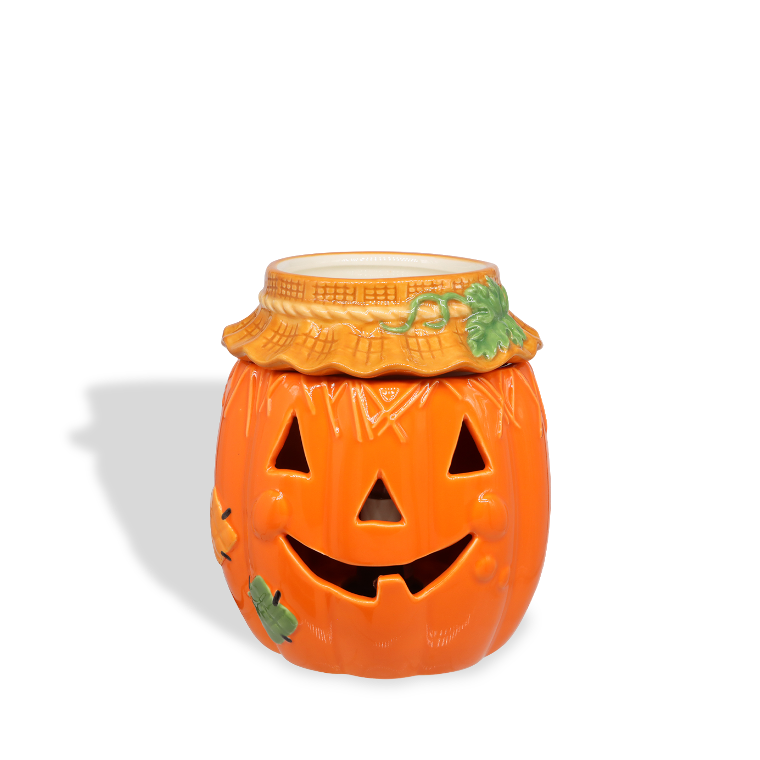 The Tuscany Candle® SEASONAL Pumpkin Wax Melt Warmer features a ceramic jack-o’-lantern design with a carved smiling face, leaf accents, and an orange finish—perfect for adding autumn fragrance to your home. Placed against a white background.