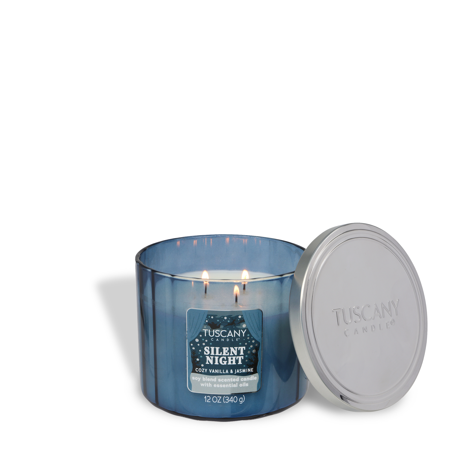 A lit Tuscany Candle® SEASONAL “Silent Night: Cozy Vanilla & Jasmine Scented Holiday Candle” (12 oz) from the Winter Icons Collection, shown in blue with two wicks and its silver lid off to the side.