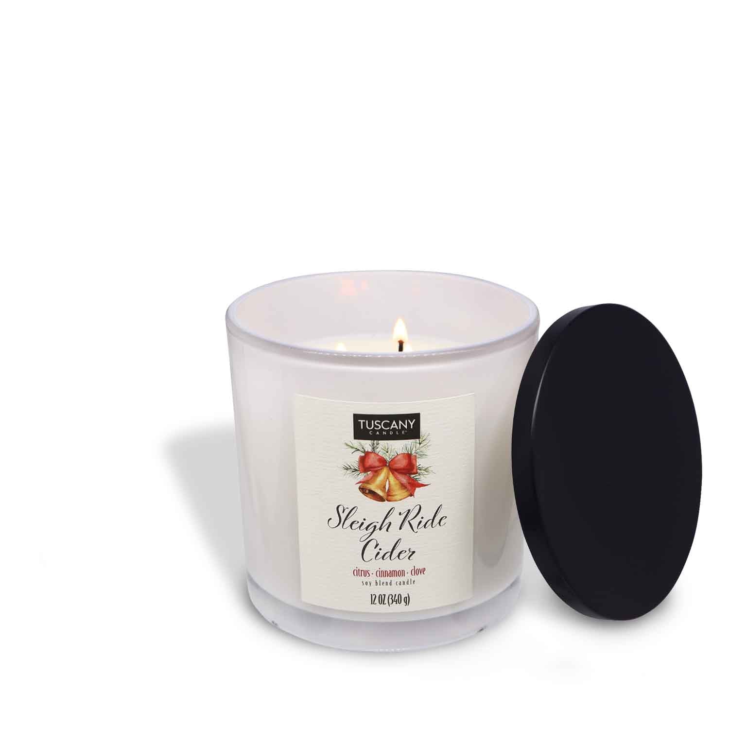 12oz Sleigh Ride Cider scented candle in a glossy white glass jar with a gold lid, evoking the scent of crisp citrus intertwined with warming cinnamon from the Winter candle collection.