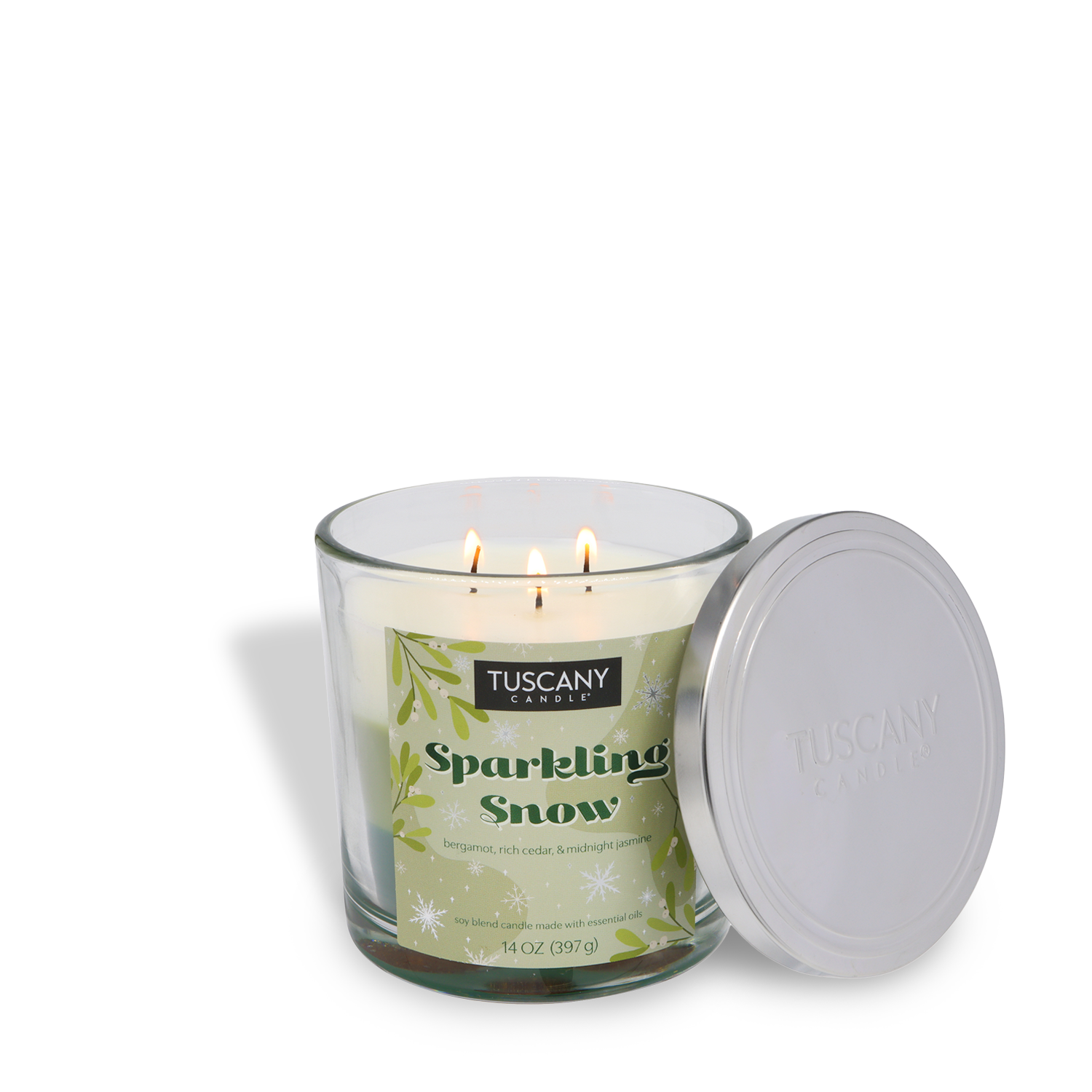 A lit Tuscany Candle® SEASONAL Sparkling Snow Scented Holiday Candle (14 oz) in a glass jar, with the silver lid removed and placed beside it.