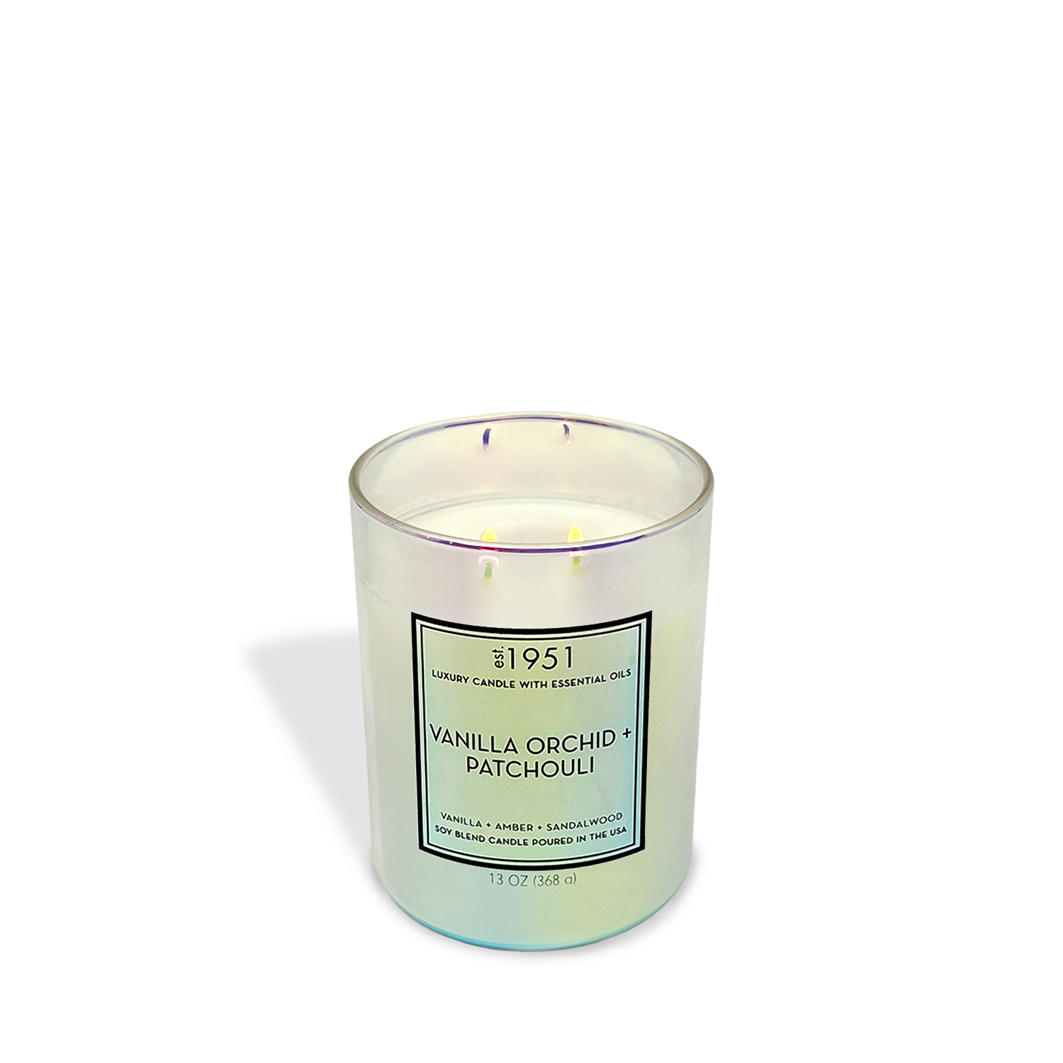 The est.1951 Vanilla Orchid & Patchouli (13oz) candle with three lit wicks fills the air with amber and patchouli notes, shown in a glass vessel against a plain white background.