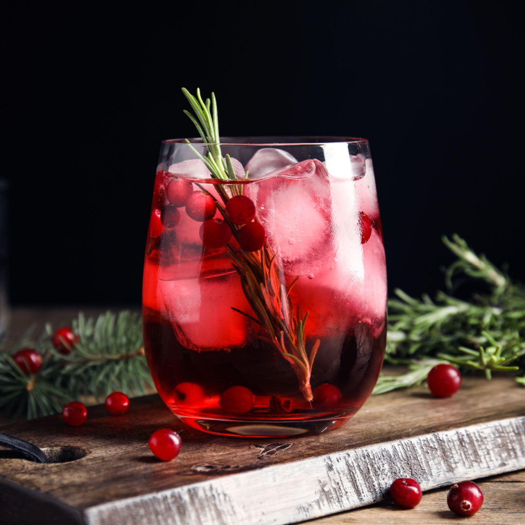A still life of a iced cranberry spritzer cocktail - the holiday inspiration for our "Sparkling Cranberry" christmas candle