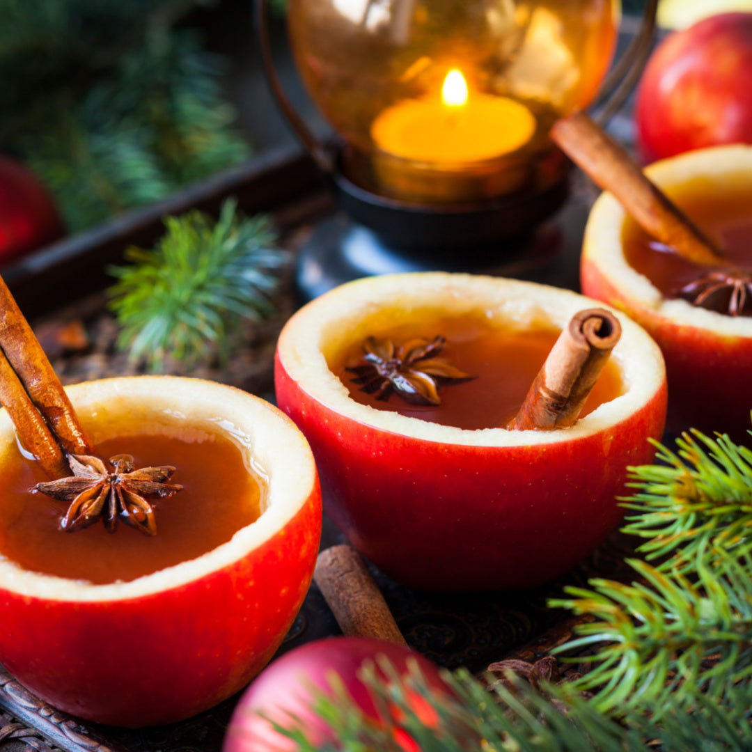 Holiday apple cider is served in hollowed-out apples. This cocktail is reminiscent of a scented candle