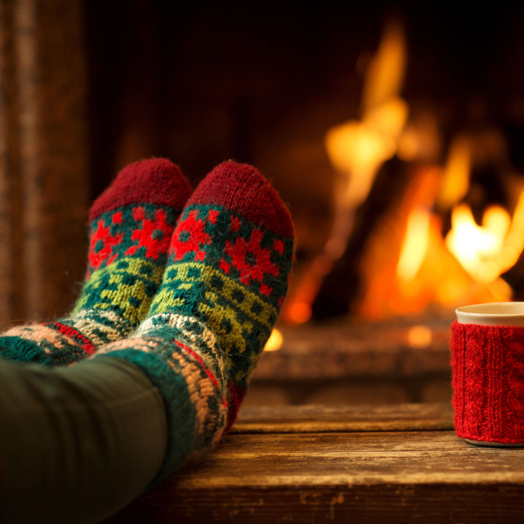 Feet in Christmas socks in from of a roaring fire - exactly the sensation that inspired our "Fireside Comfort" holiday scented candle
