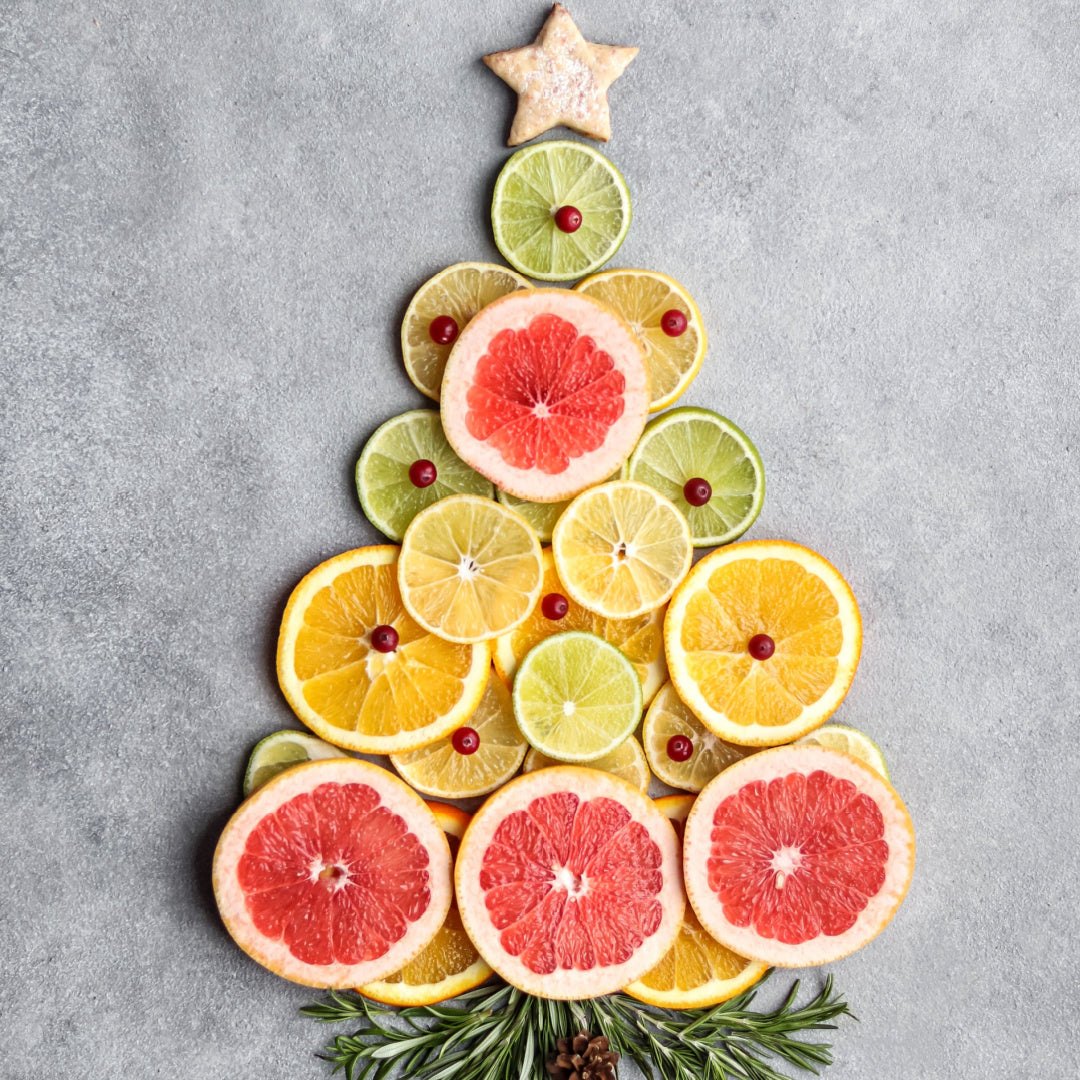 2oz Holiday Spirit scented candle in a glossy white glass jar with a gold lid, releasing a harmonious blend of sparkling grapefruit, pomegranate, and amber from the Winter candle collection.