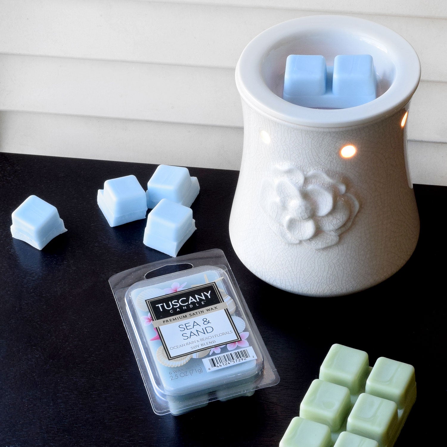 A light blue Sea & Sand tart bar is shown being used in one of our ceramic wax melt warmers