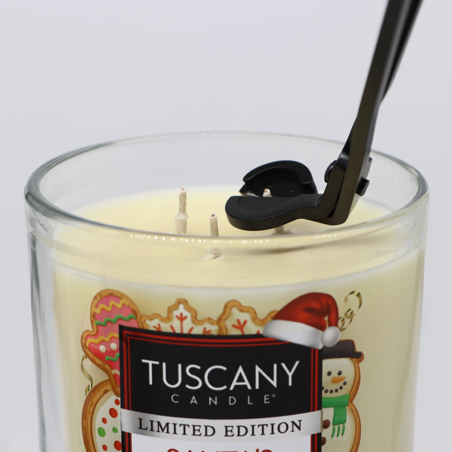 A 3-Piece Candle Care Set by Tuscany Candle, including a candle in a glass with a stainless steel spoon for added elegance and candle care.