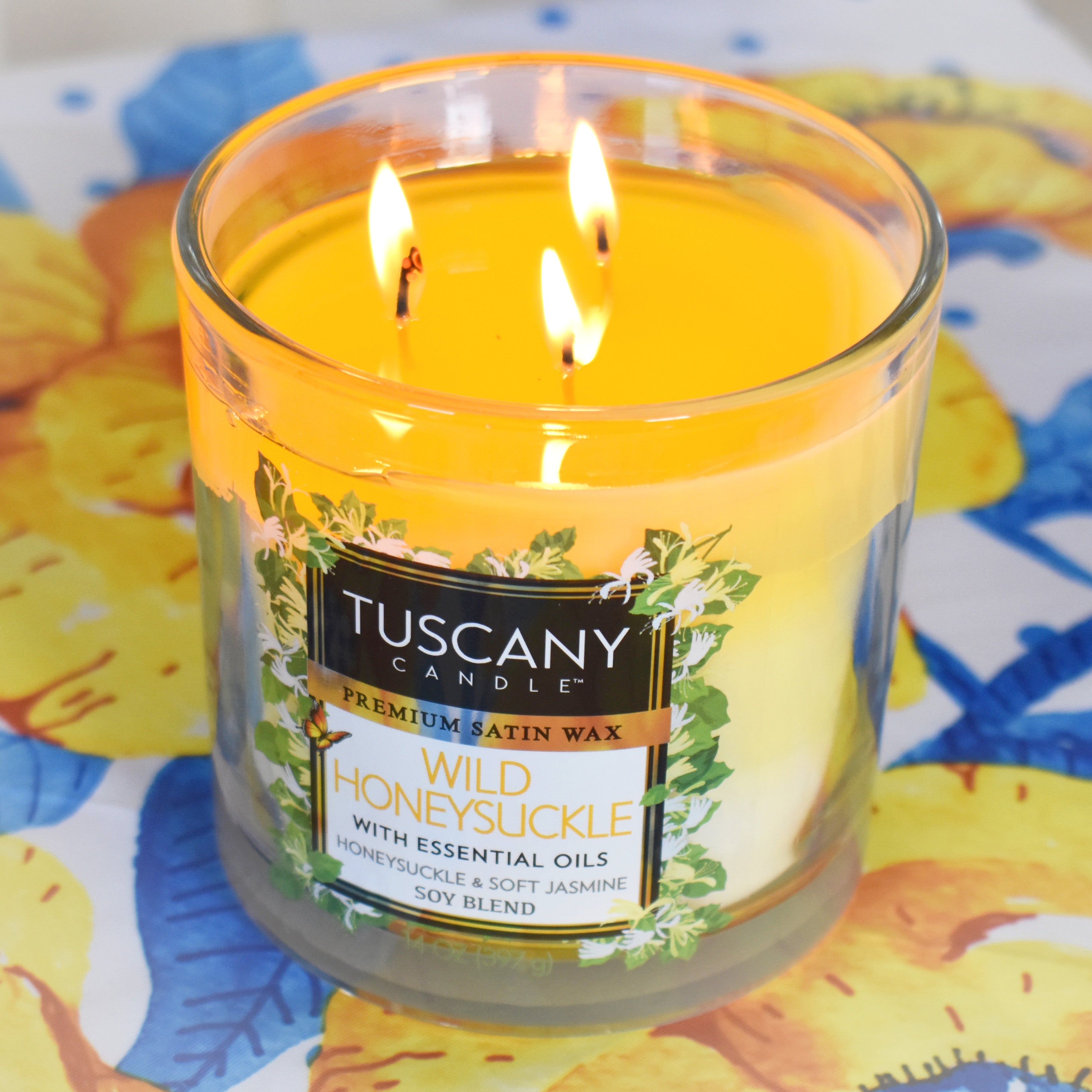 This Tuscany Candle Wild Honeysuckle Long-Lasting Scented Jar Candle (14 oz) captures the essence of wild honeysuckle from Tuscany, with its captivating fragrance filling any space with a delightful aroma.