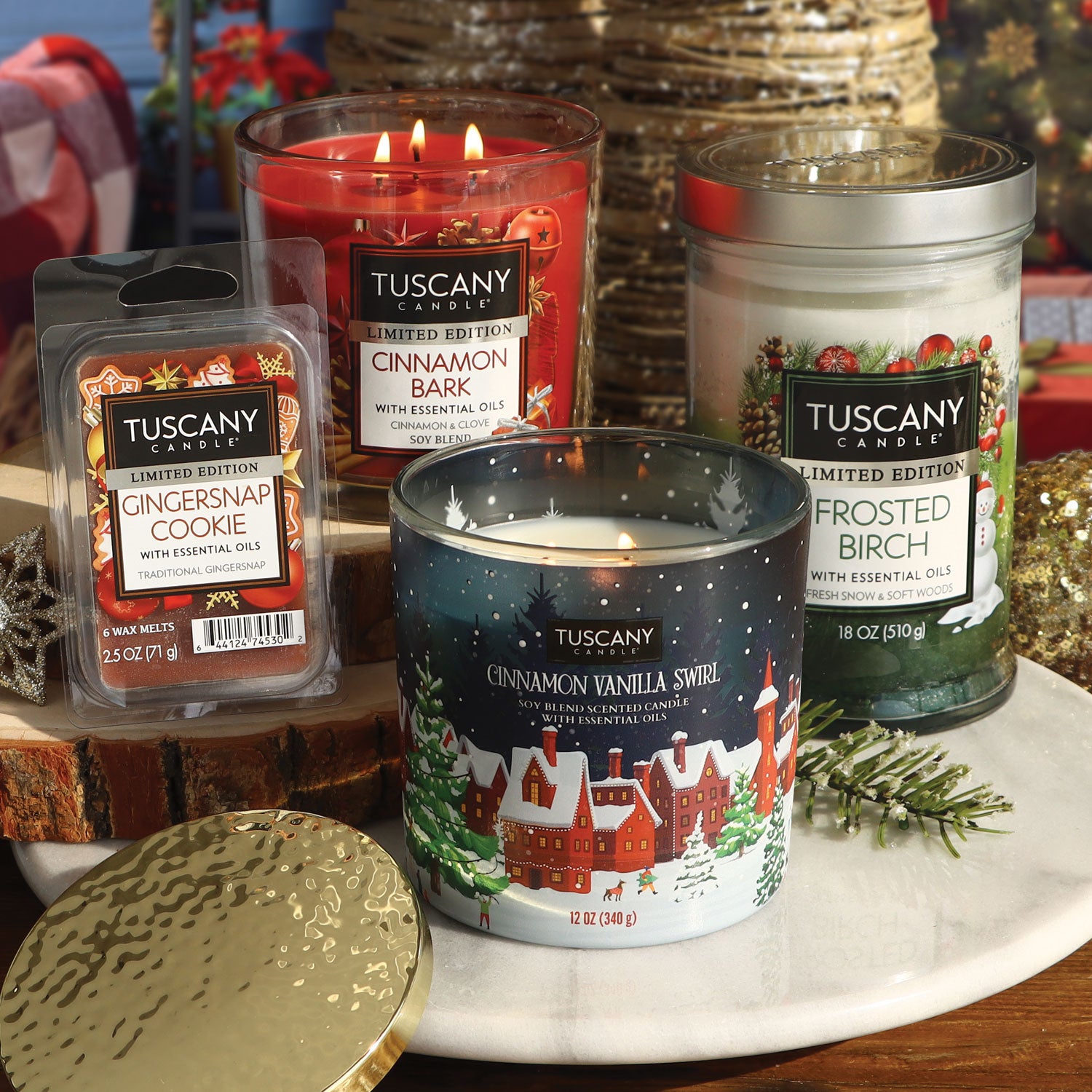 Several Christmas candles and holiday wax melts are grouped together in a still life arrangement