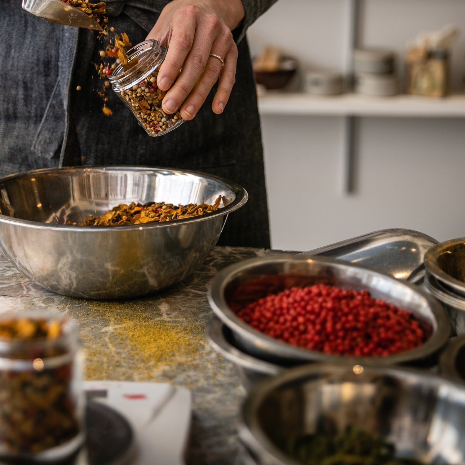 A man is sprinkling warm Tuscany Candle Kitchen Spice Long-Lasting Scented Jar Candle (14 oz) into a bowl.