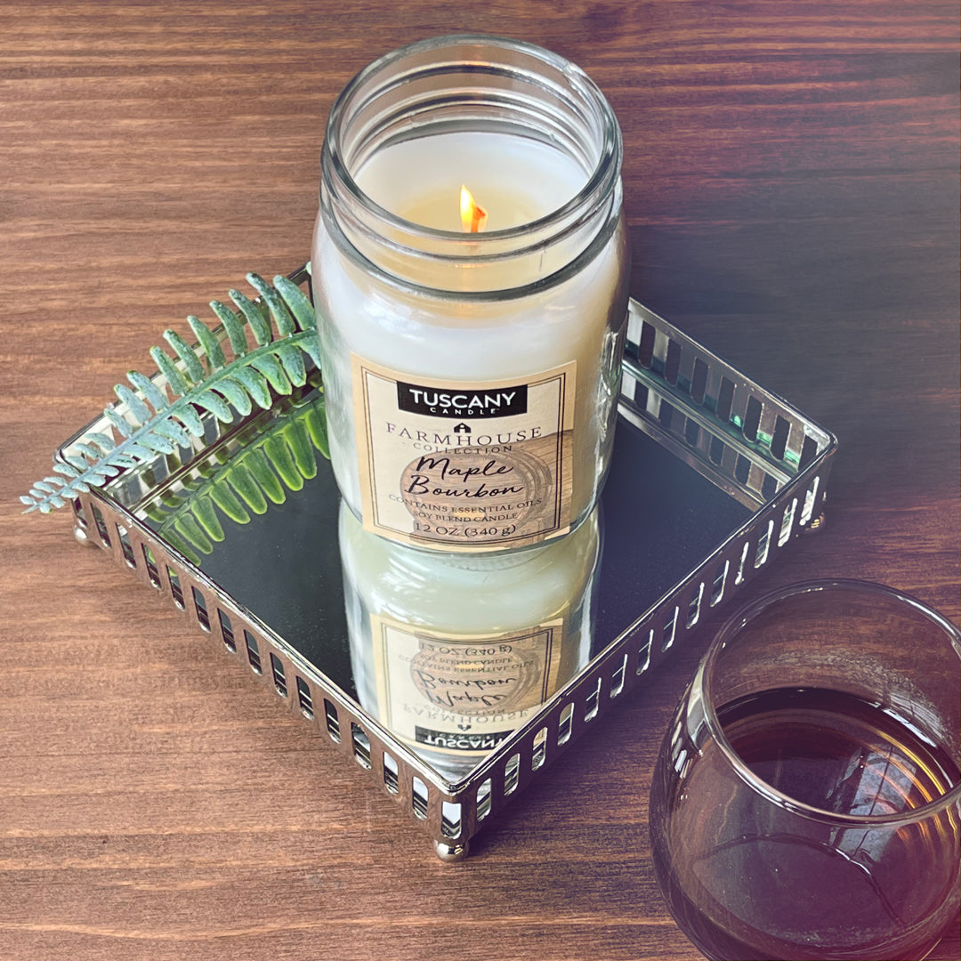 A glass of wine and a Maple Bourbon Scented Jar Candle (12 oz) from Tuscany Candle on a tray, creating a cozy farmhouse ambiance for scent enthusiasts.