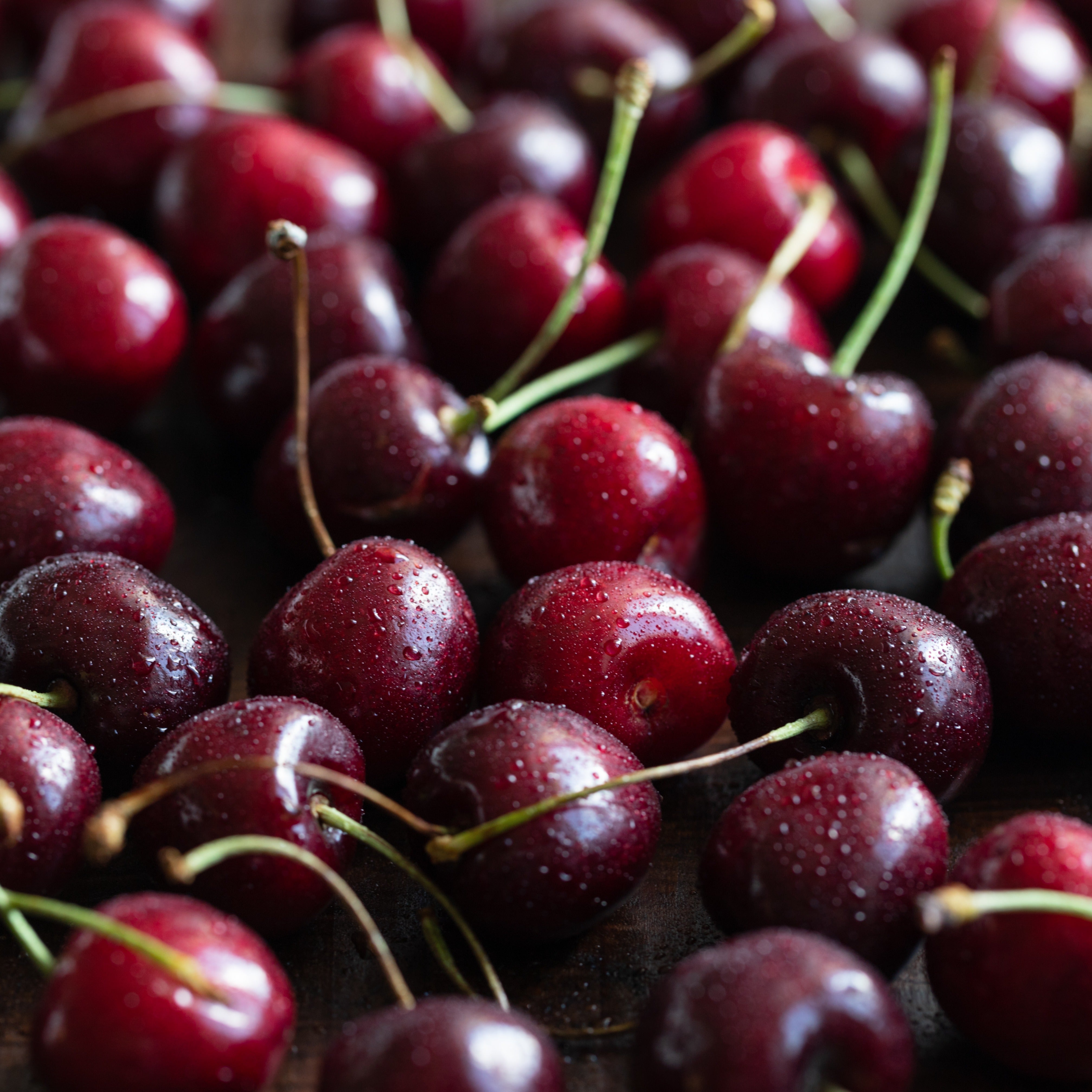 A close up of Tuscany Candle Black Cherry Scented Wax Melt (2.5 oz) with water droplets on them.