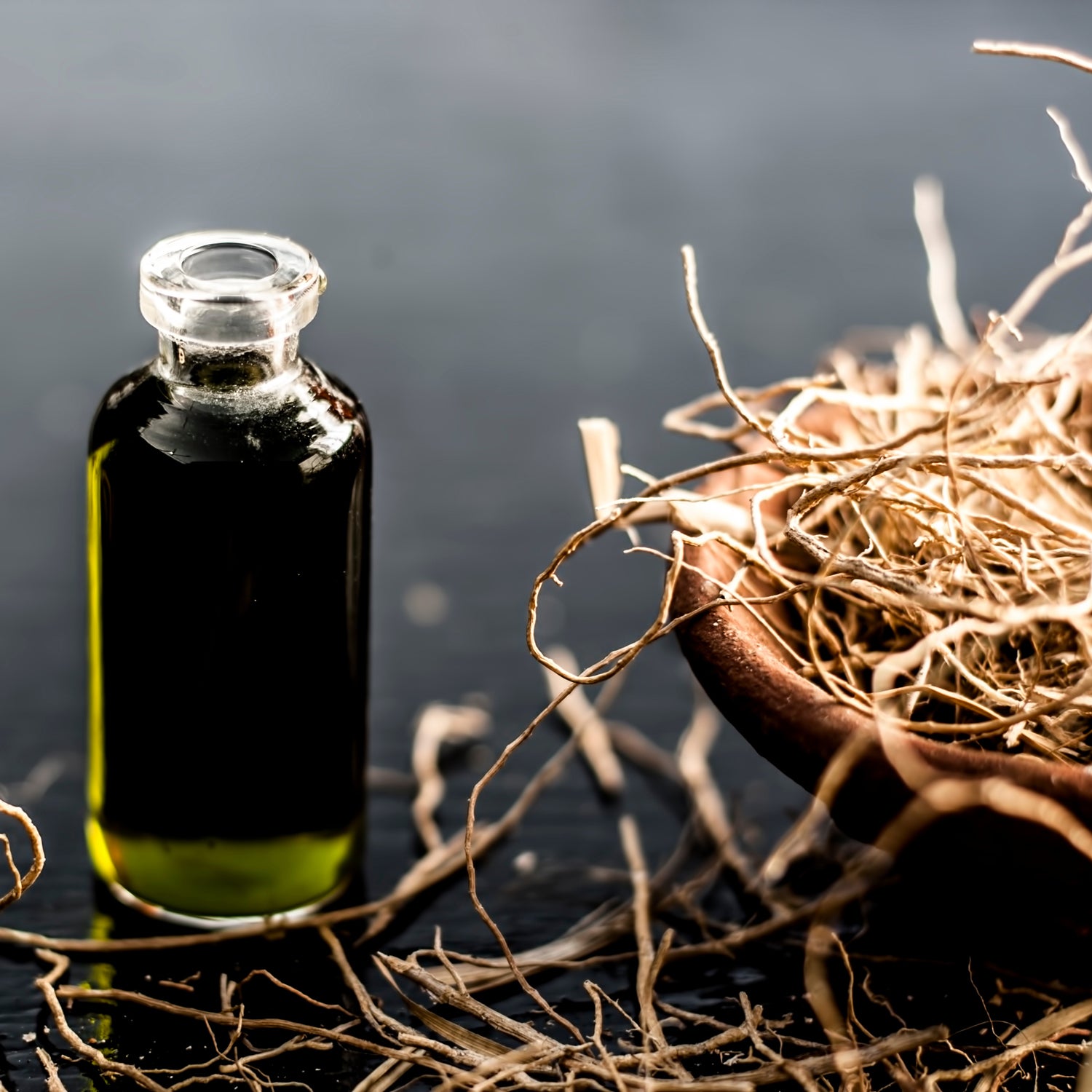 A still-life photo of Vetiver, one of the components of "Woodland Waterfall," a unisex scented candle from Tuscany Candle which seamlessly blends the invigorating essence of Fresh Ocean Air with the earthy undertones of Weathered Driftwood and a hint of Vetiver